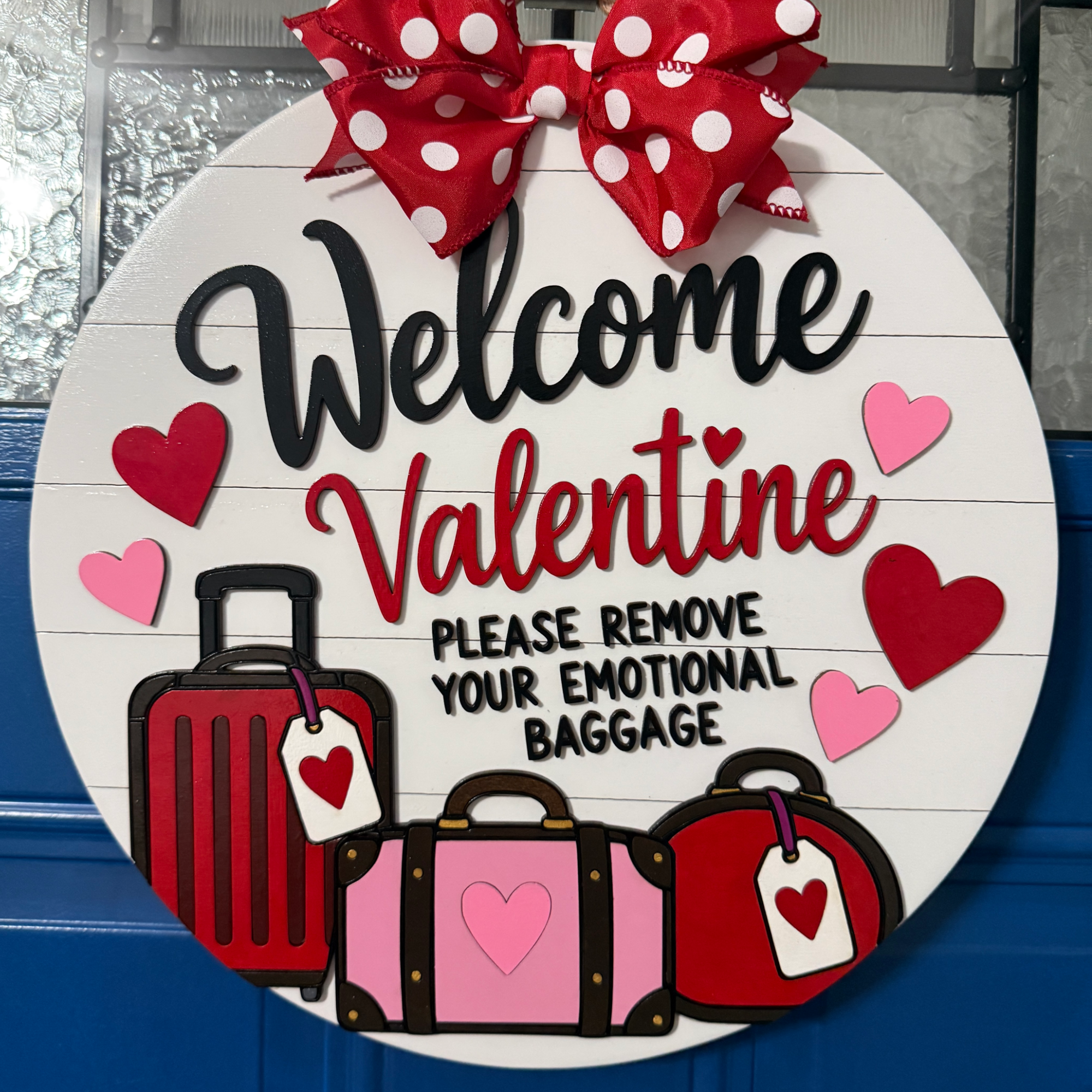 Welcome Valentine emotional baggage door hanger with red and pink suitcases, hearts, and red polka dot bow