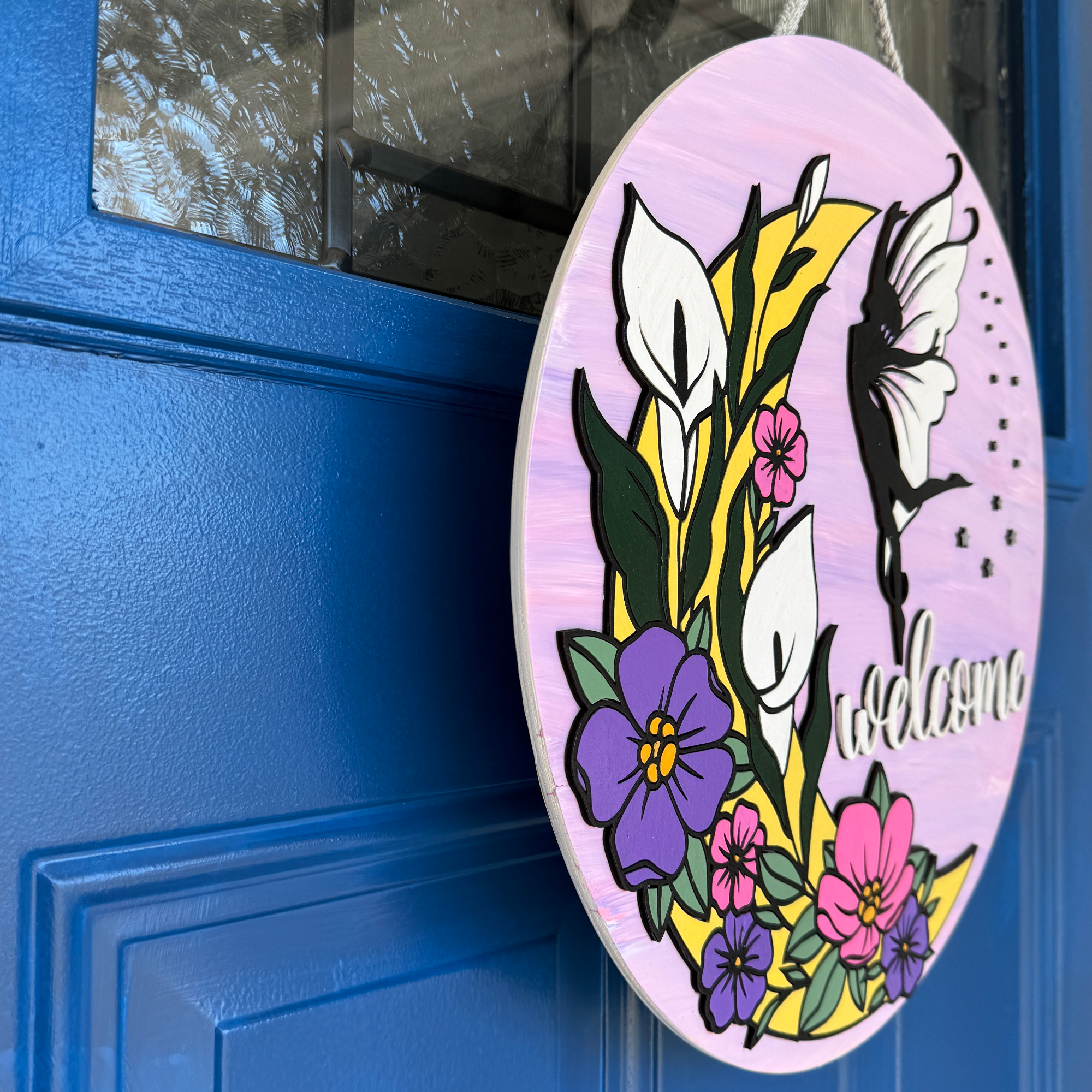 Side view of black fairy silhouette with white wings and star accents on pink background door hanger