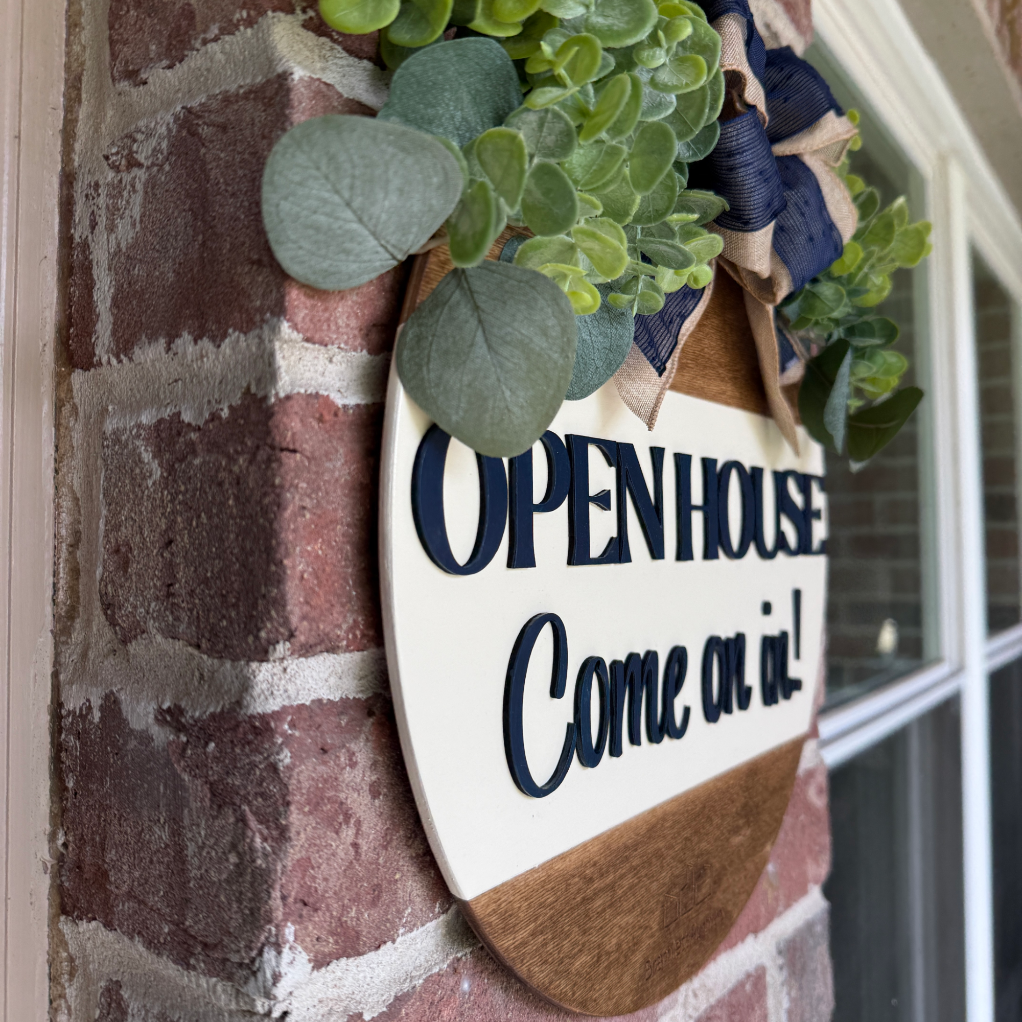Handmade wood realtor sign with navy lettering, greenery, and decorative bow.