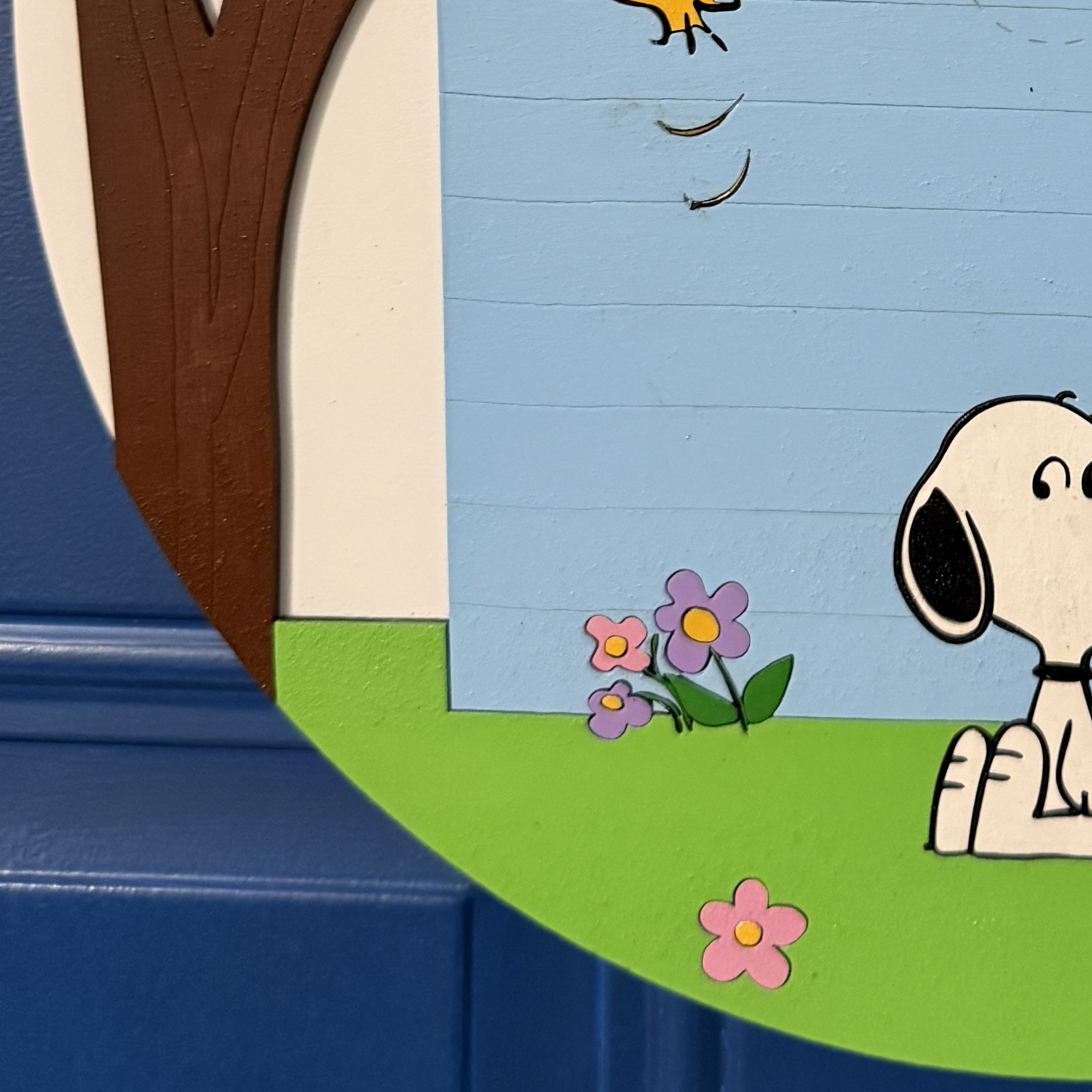 Close-up of cartoon dog sitting on green grass with flowers and spring scene