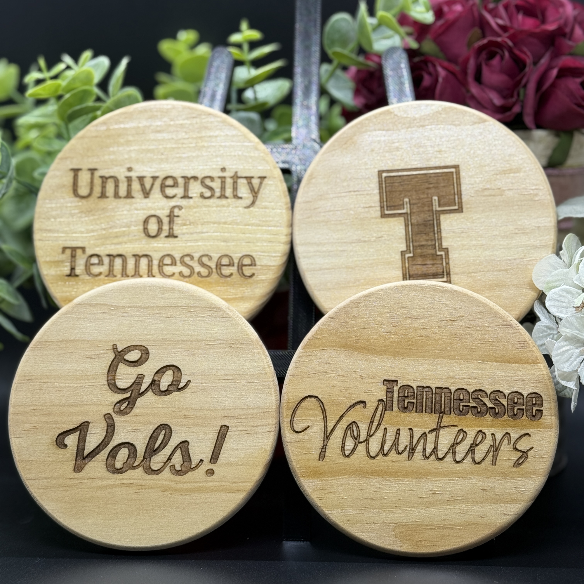 Set of four round Tennessee Volunteers engraved wooden coasters with designs including University of Tennessee, block T logo, Go Vols, and Tennessee Volunteers