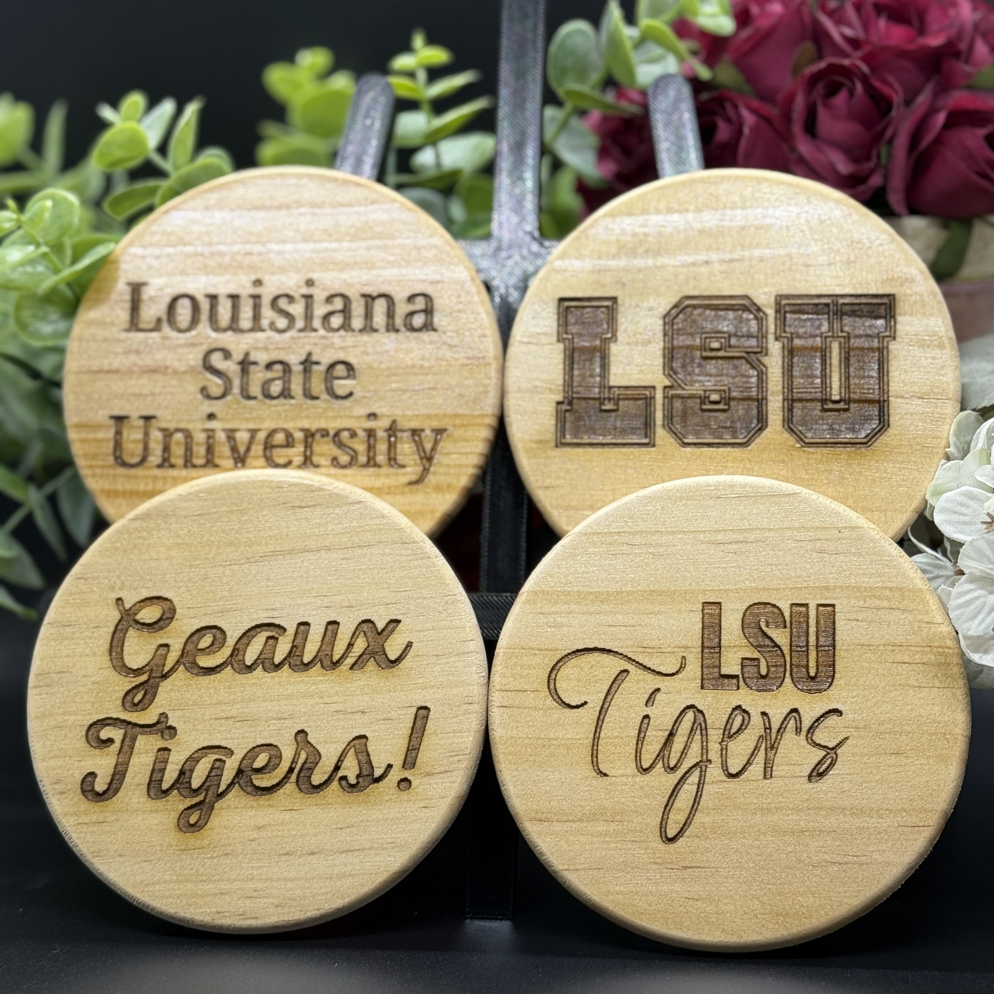 Set of four round LSU engraved wooden coasters with designs including Louisiana State University, LSU lettermark, Geaux Tigers, and LSU Tigers