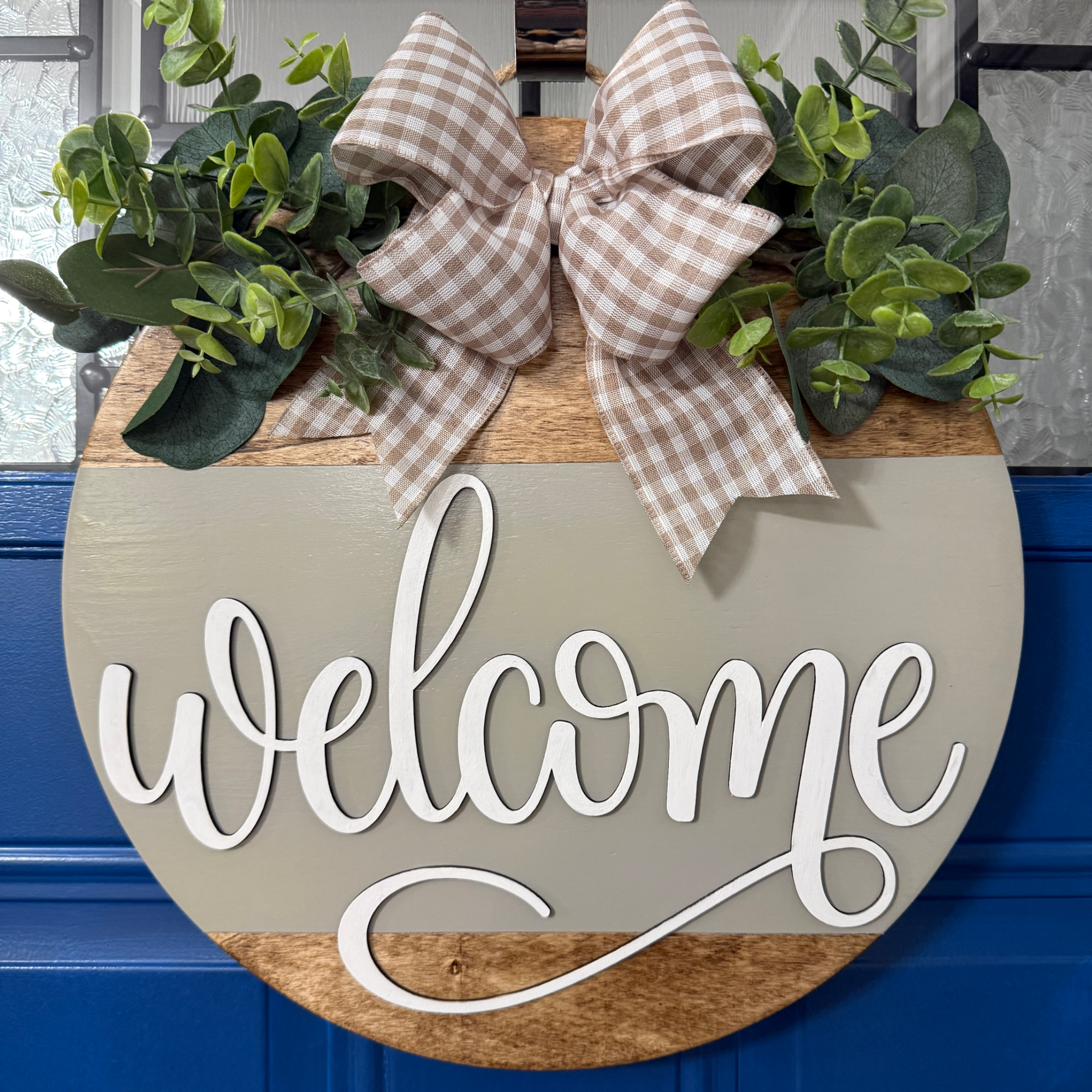 Welcome door hanger on stained base with greige background, faux with greenery and coordinating bow