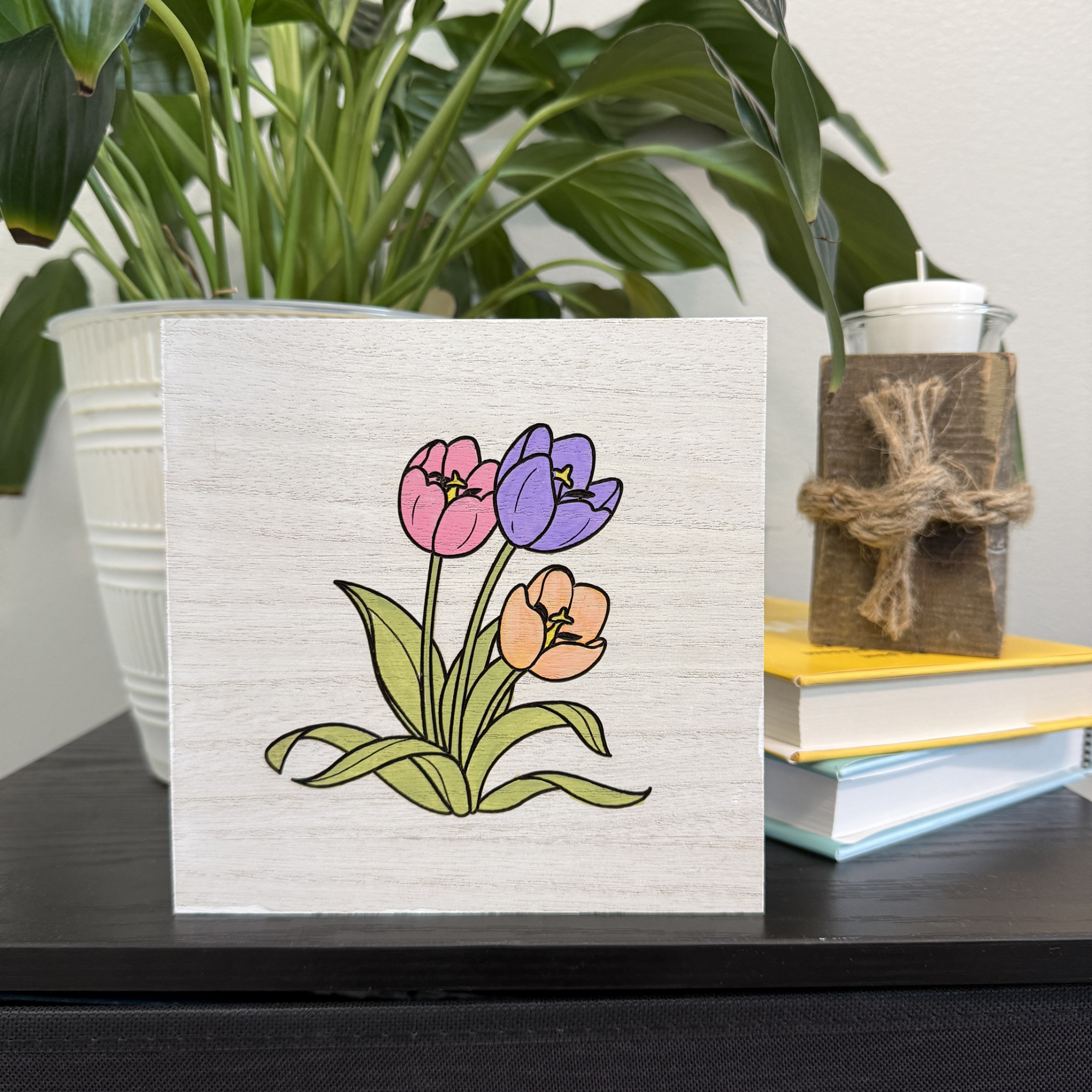 Spring tulip wooden shelf sitter styled on a shelf with stacked books and potted plant in background