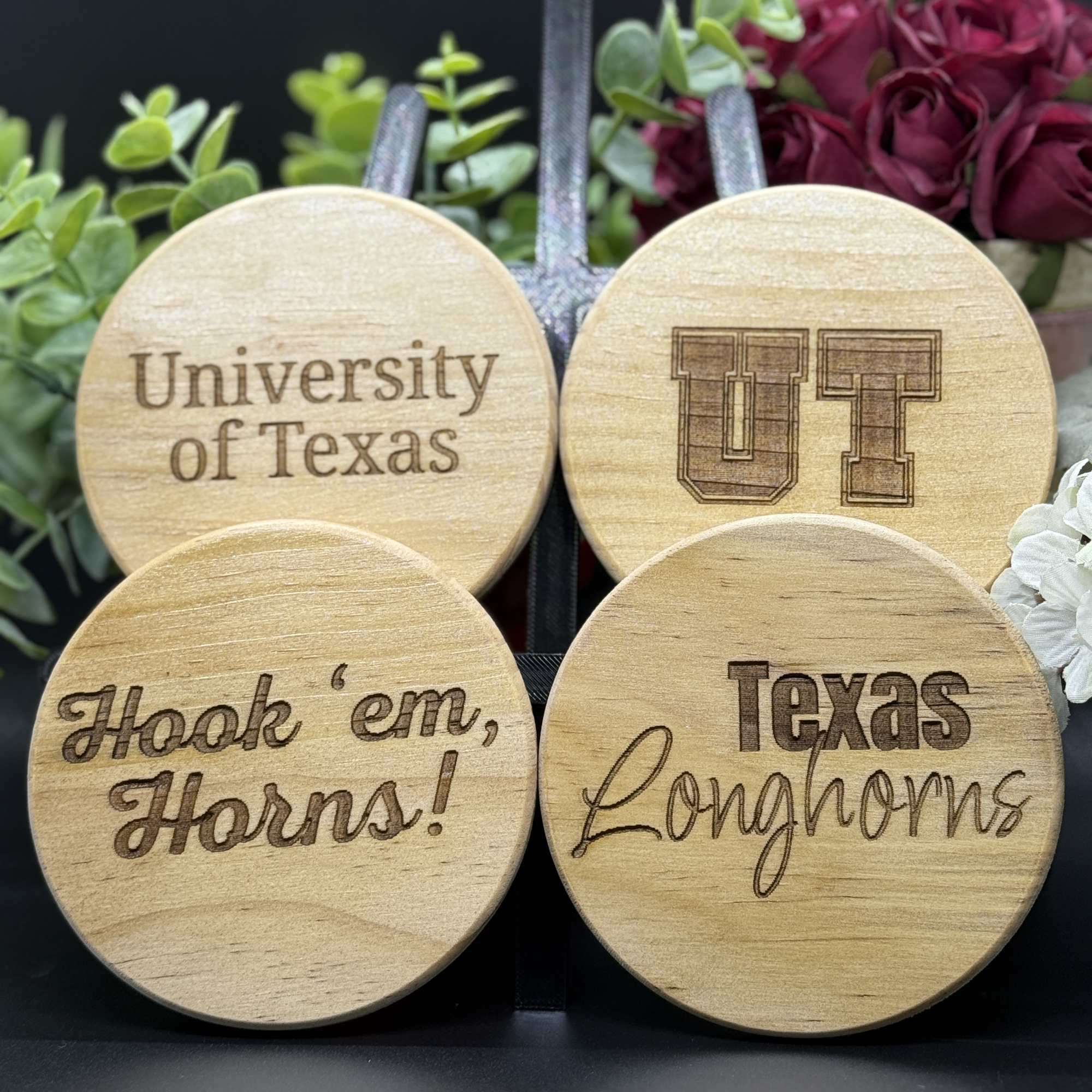 Set of four round Texas Longhorns engraved wooden coasters with designs including University of Texas, UT lettermark, Hook ’em Horns, and Texas Longhorns