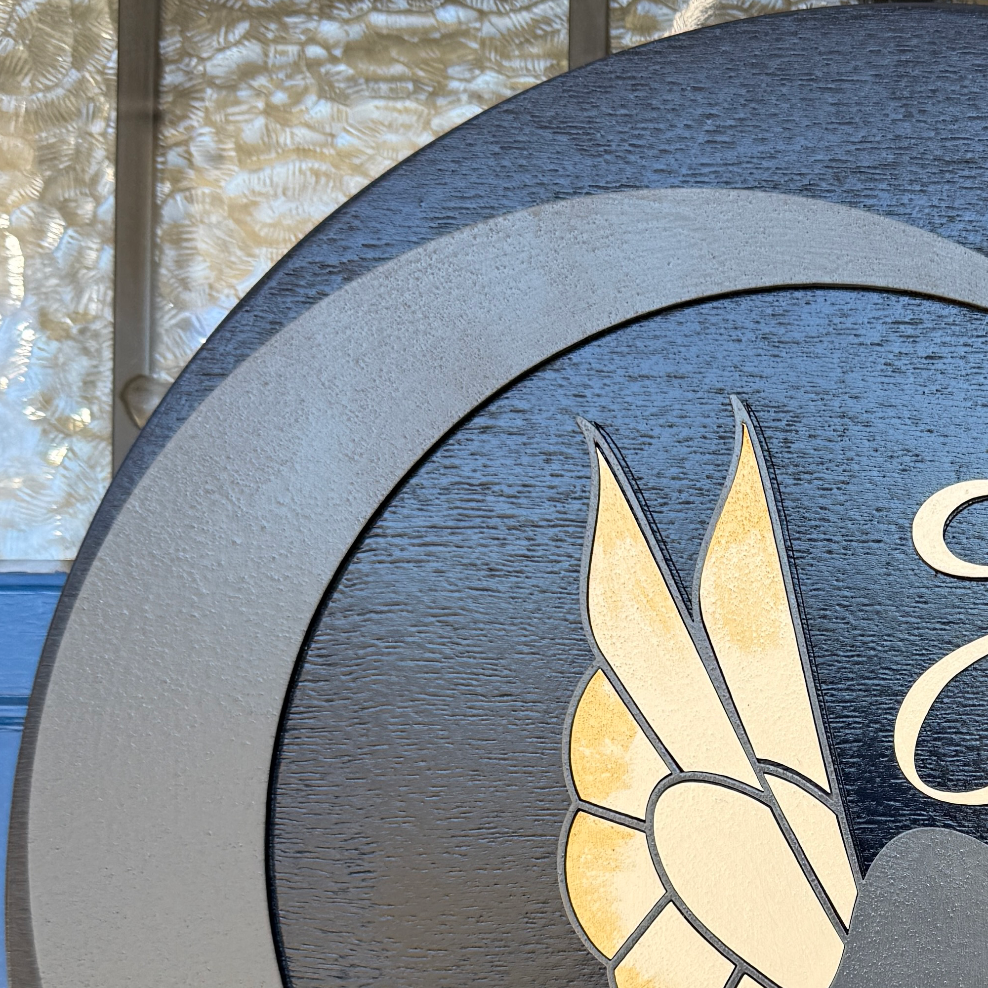 Close-up of gold fairy wings with layered wood detail on black background door hanger