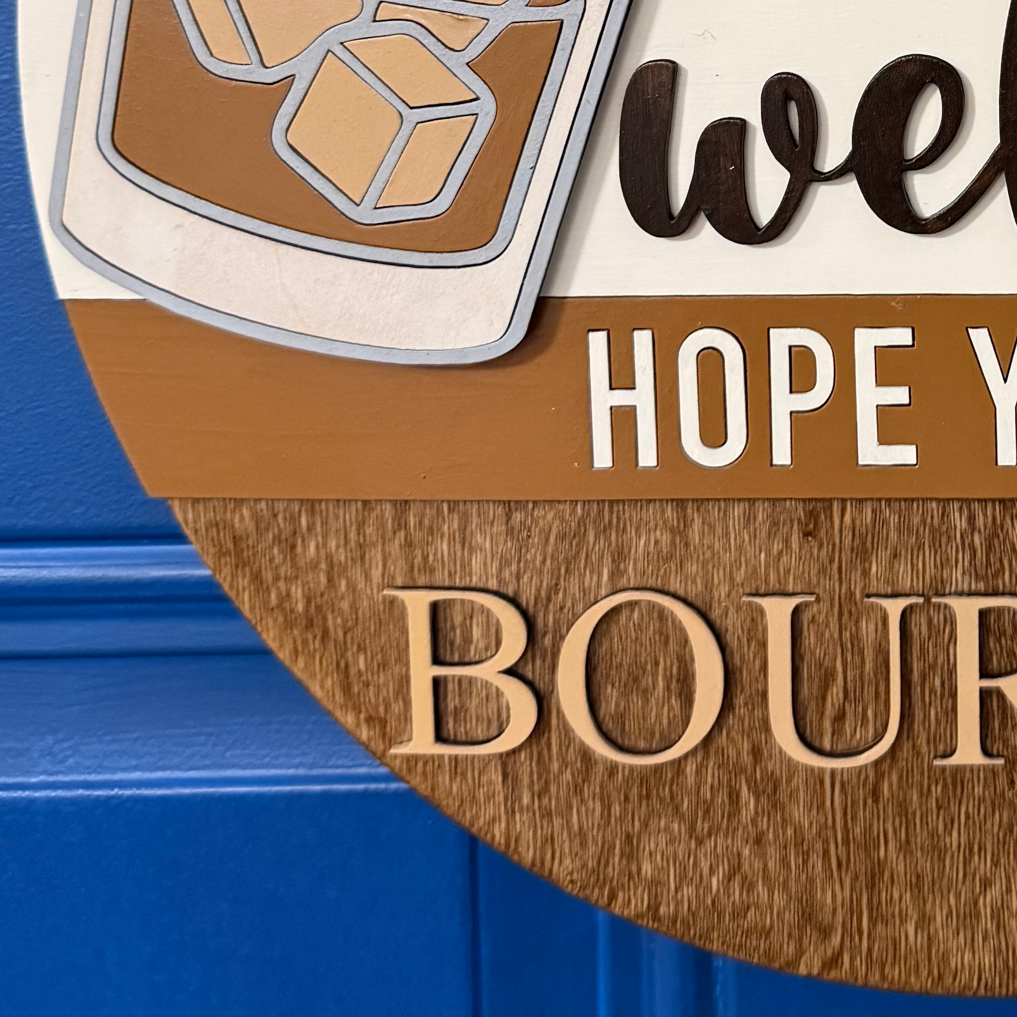 Close-up of “welcome” script lettering in dark brown on cream background