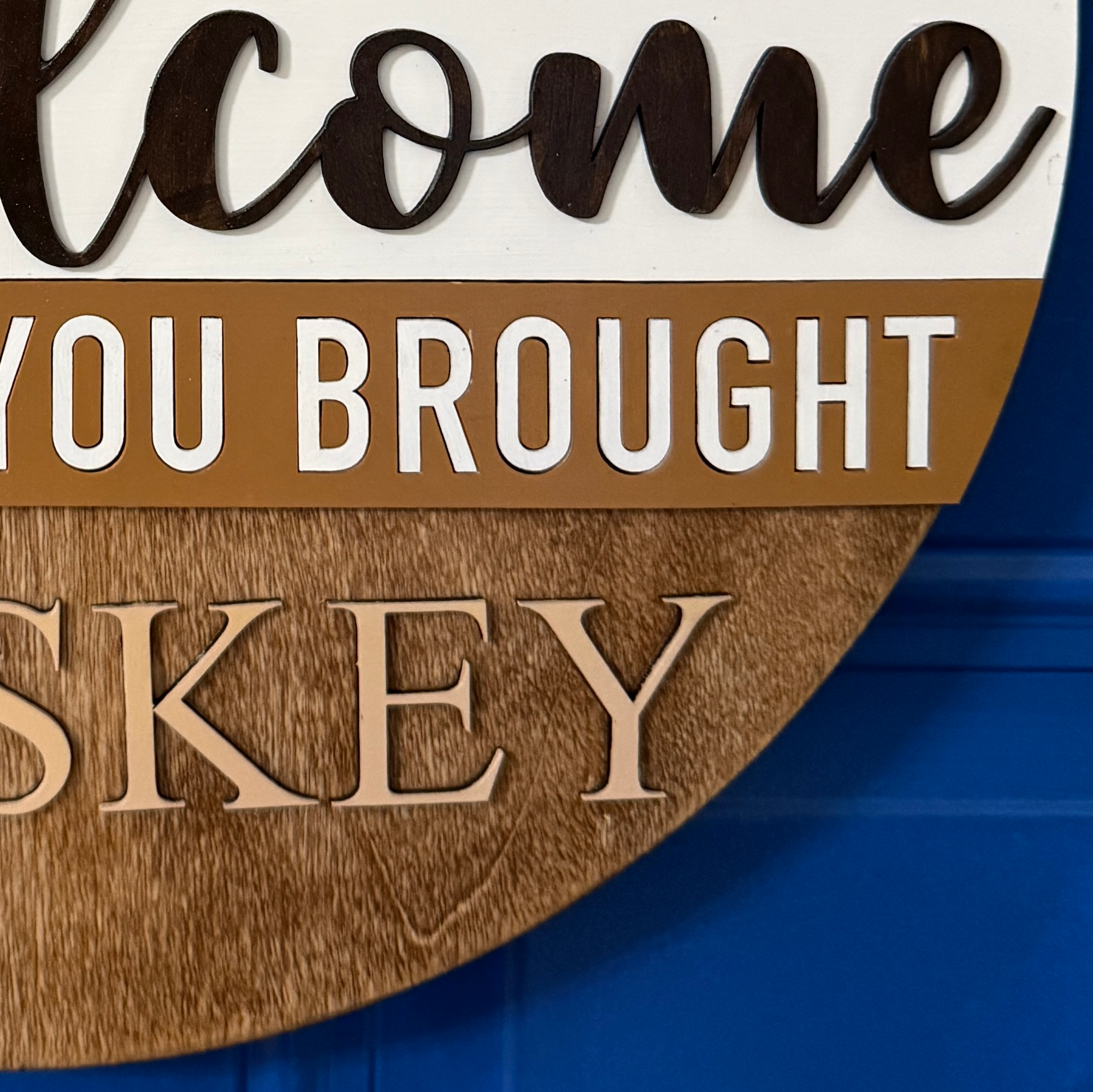 Close-up of “Hope you brought whiskey” text across middle of sign