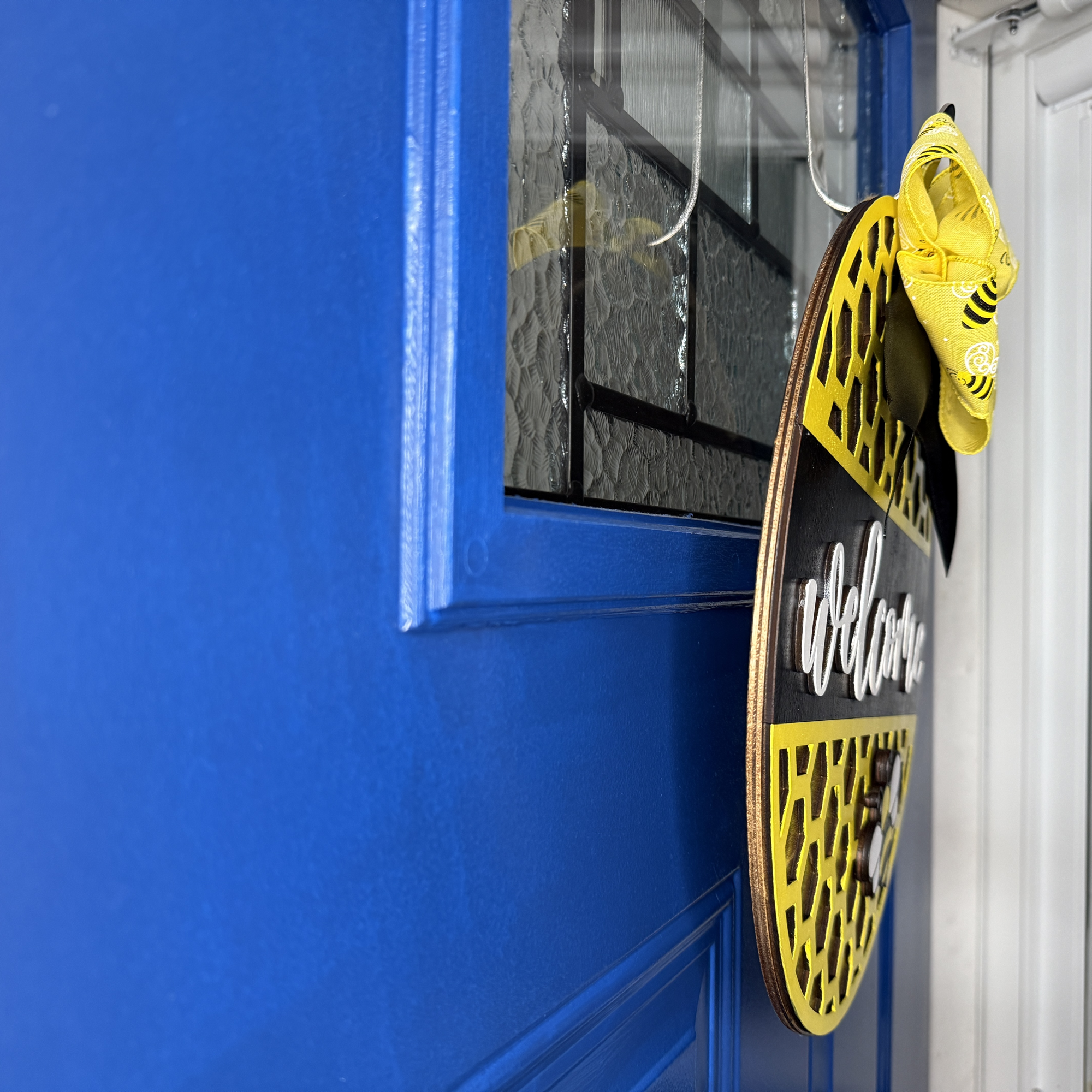 Welcome door hanger, side view, showing base thickness and layered wood details