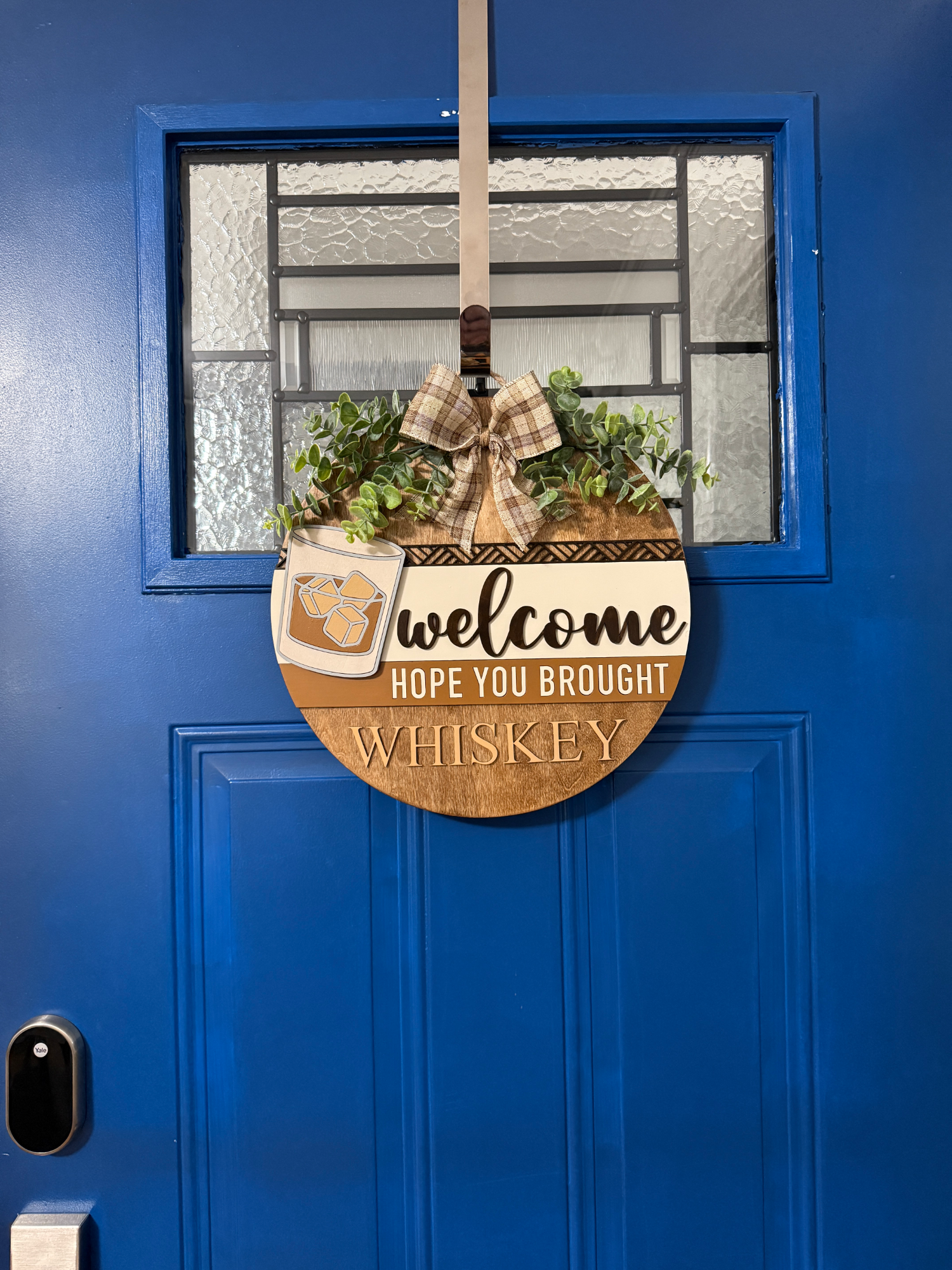 Full view of whiskey door hanger displayed on blue front door
