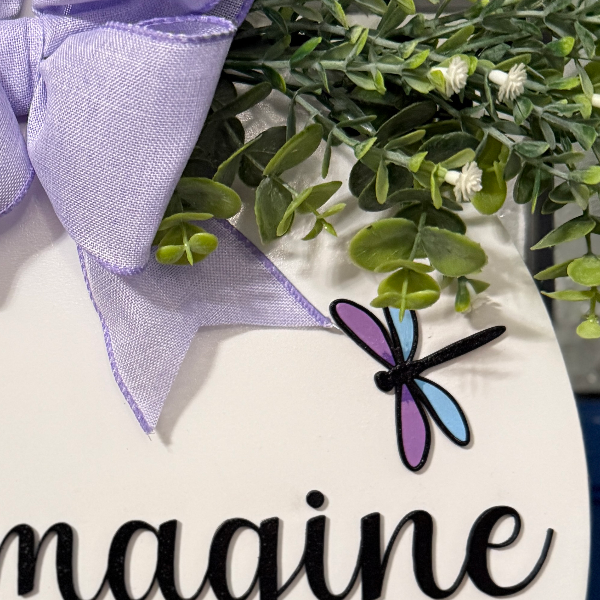 Close-up of dragonfly detail on hand-painted wooden door hanger with purple and blue wings