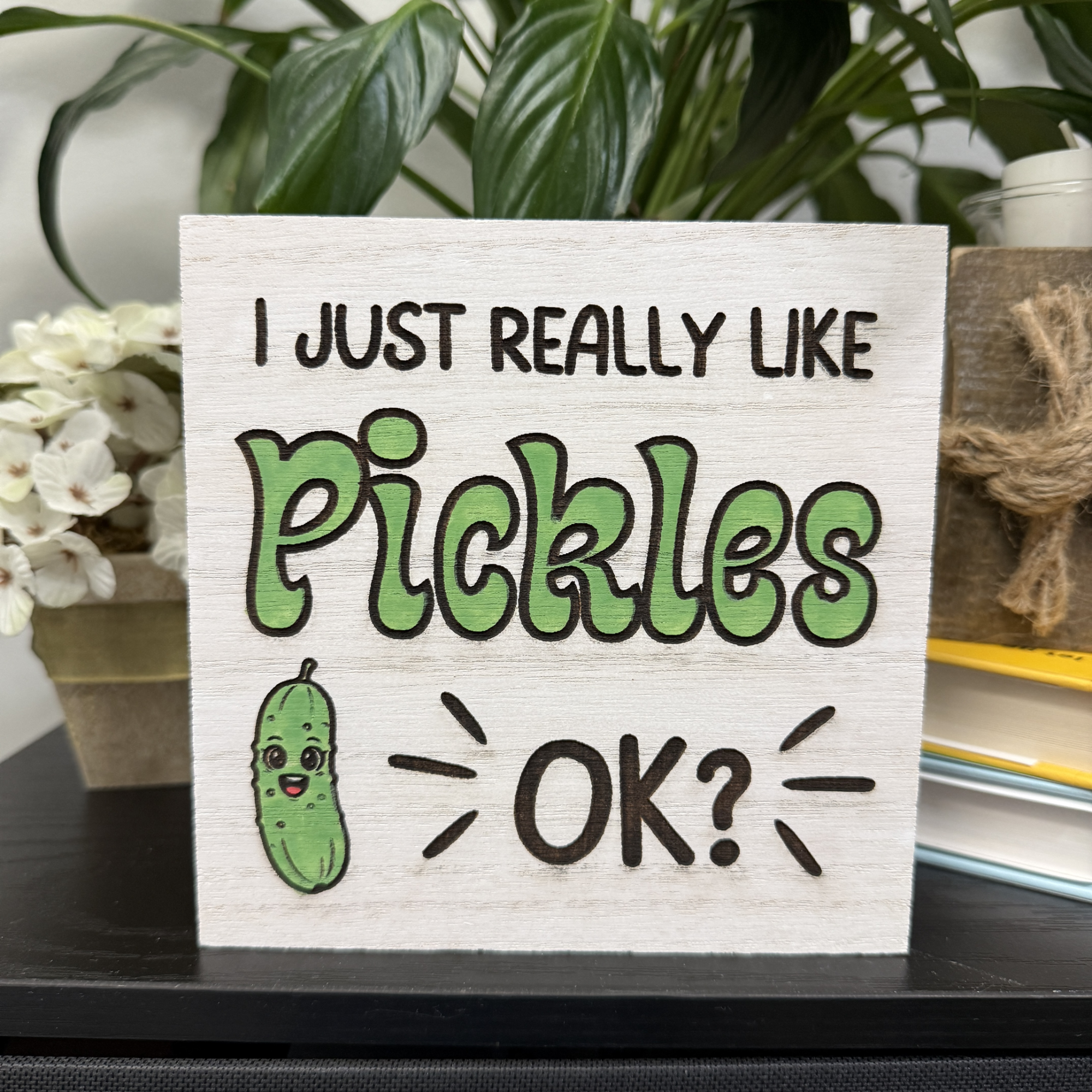 Funny pickle-themed wood sign reading “I just really like pickles OK?” with a small illustrated pickle on natural wood background