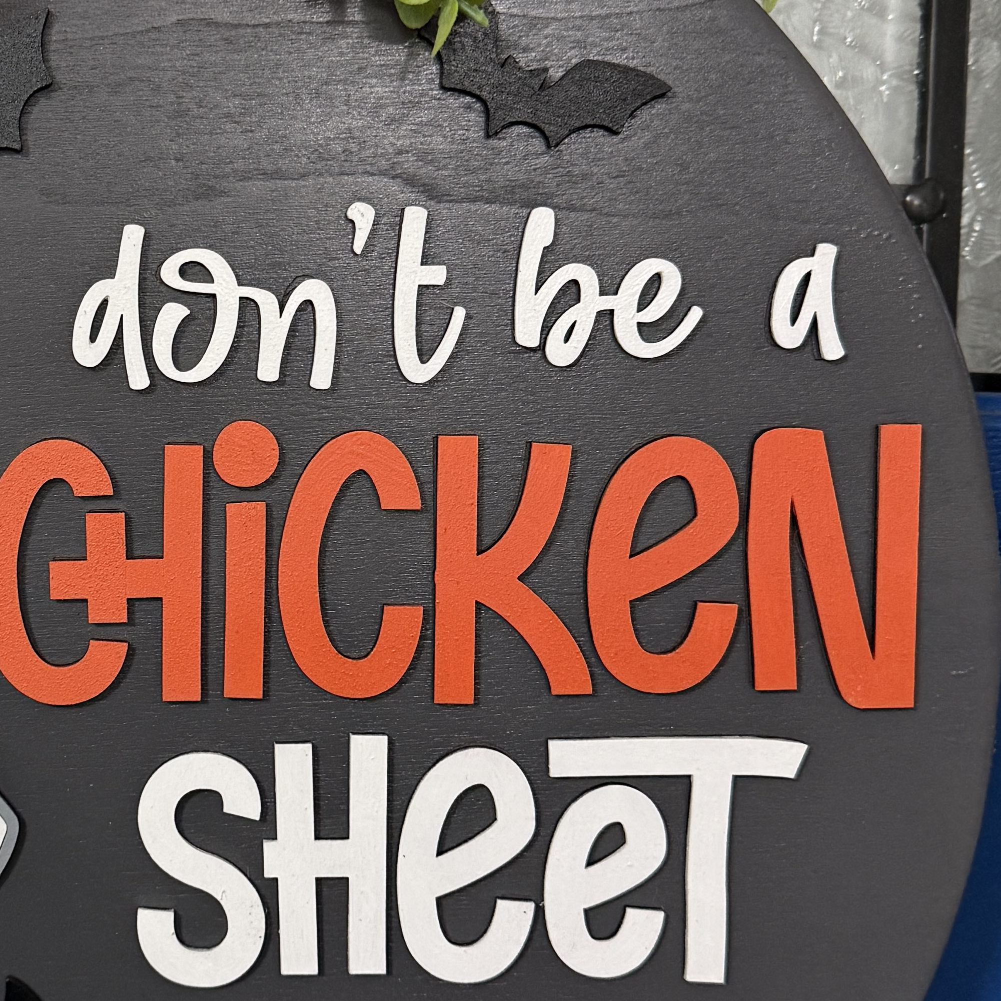 Close-up of ghost chicken character, candy corn, and jack-o’-lantern accents on the Halloween door hanger