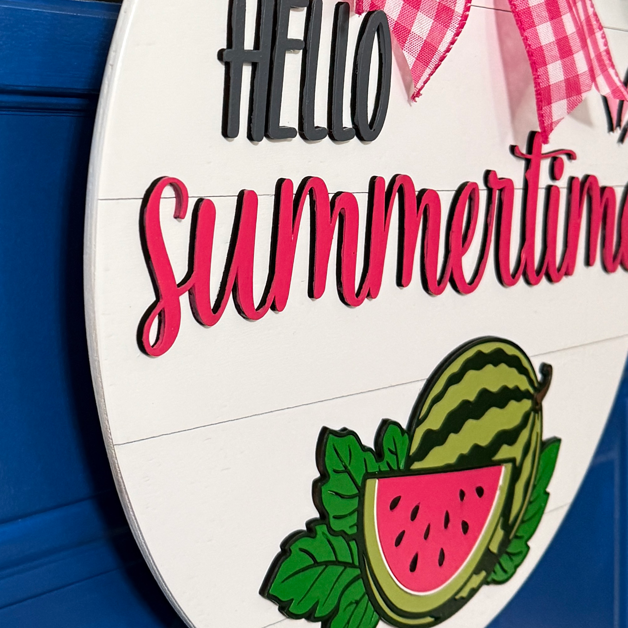 Side angle view of dimensional lettering and layered watermelon illustration on round summer door decor