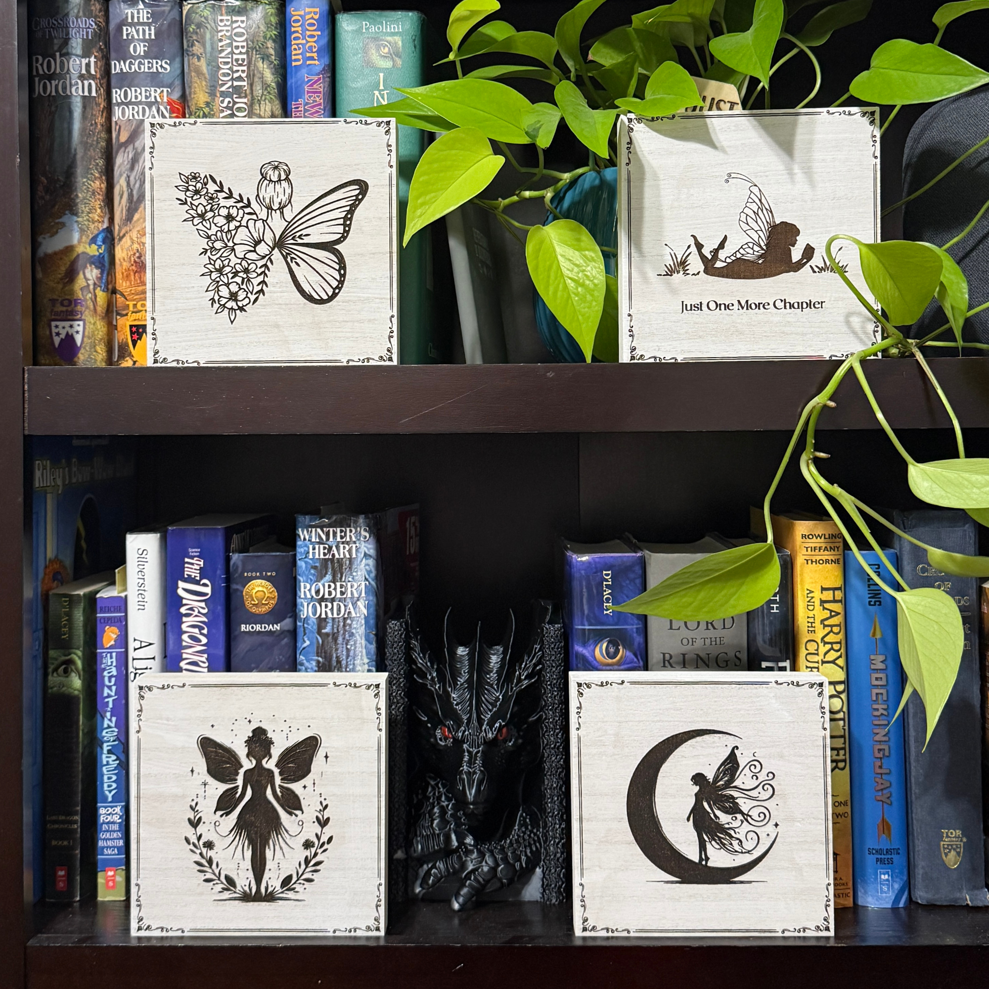 Moon fairy shelf sitter displayed on a bookshelf with fantasy decor, books, and trailing greenery