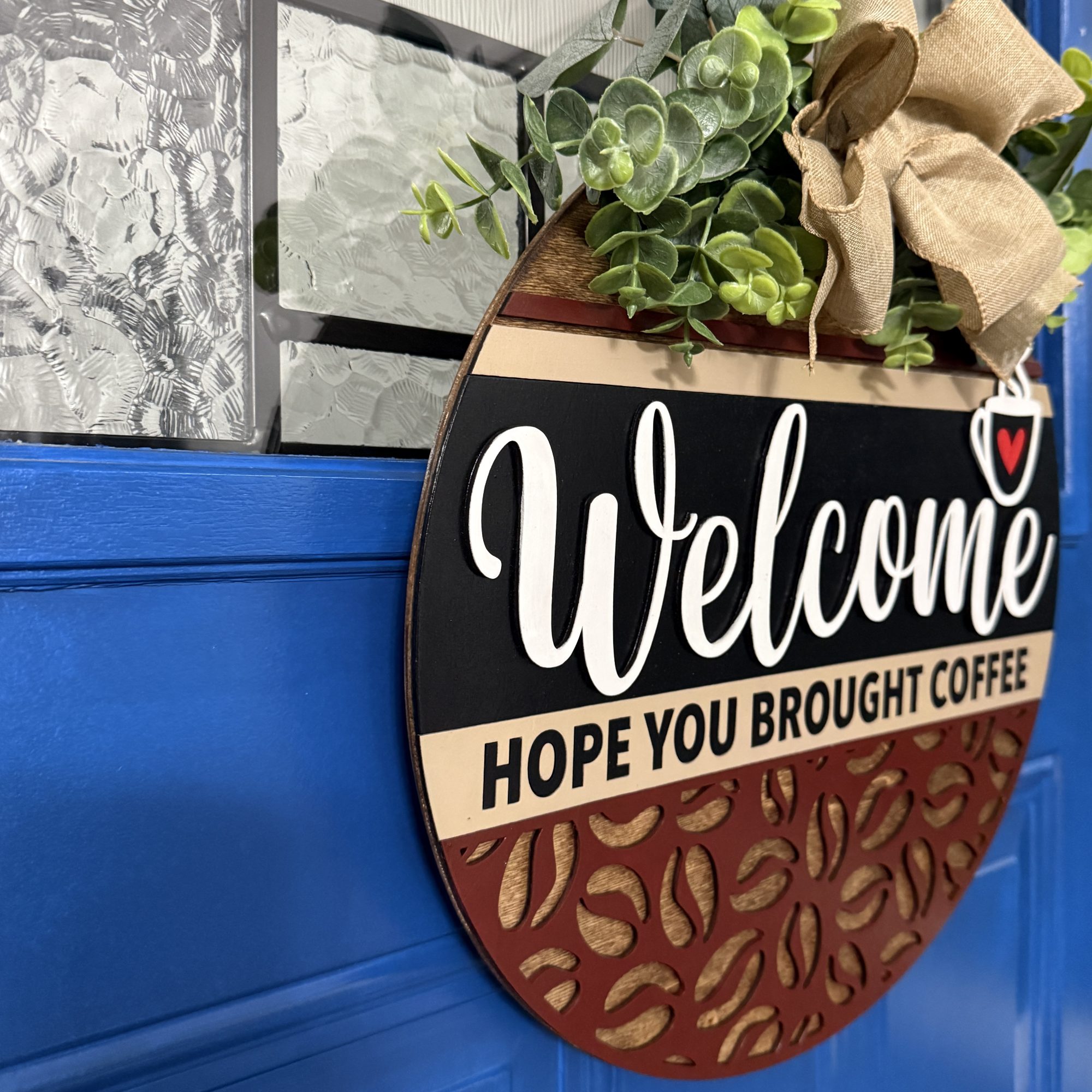 Angled view of welcome door hanger showing layered wood design and painted lettering