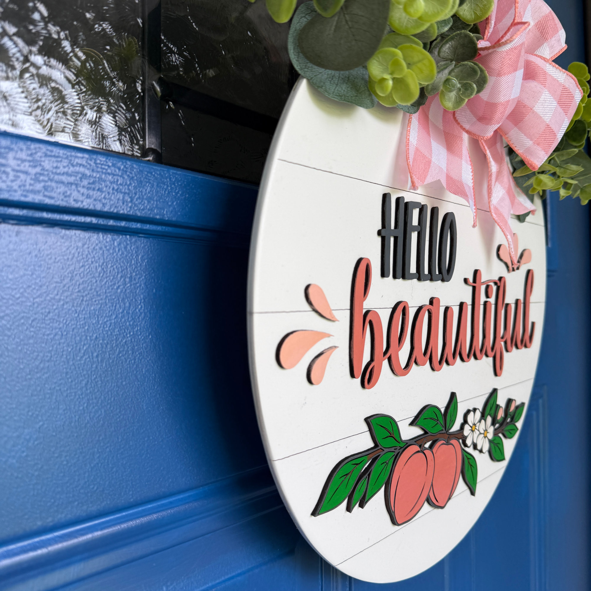 Layered wood peach door hanger featuring Hello Beautiful text, shown from an angled side view highlighting dimensional details.