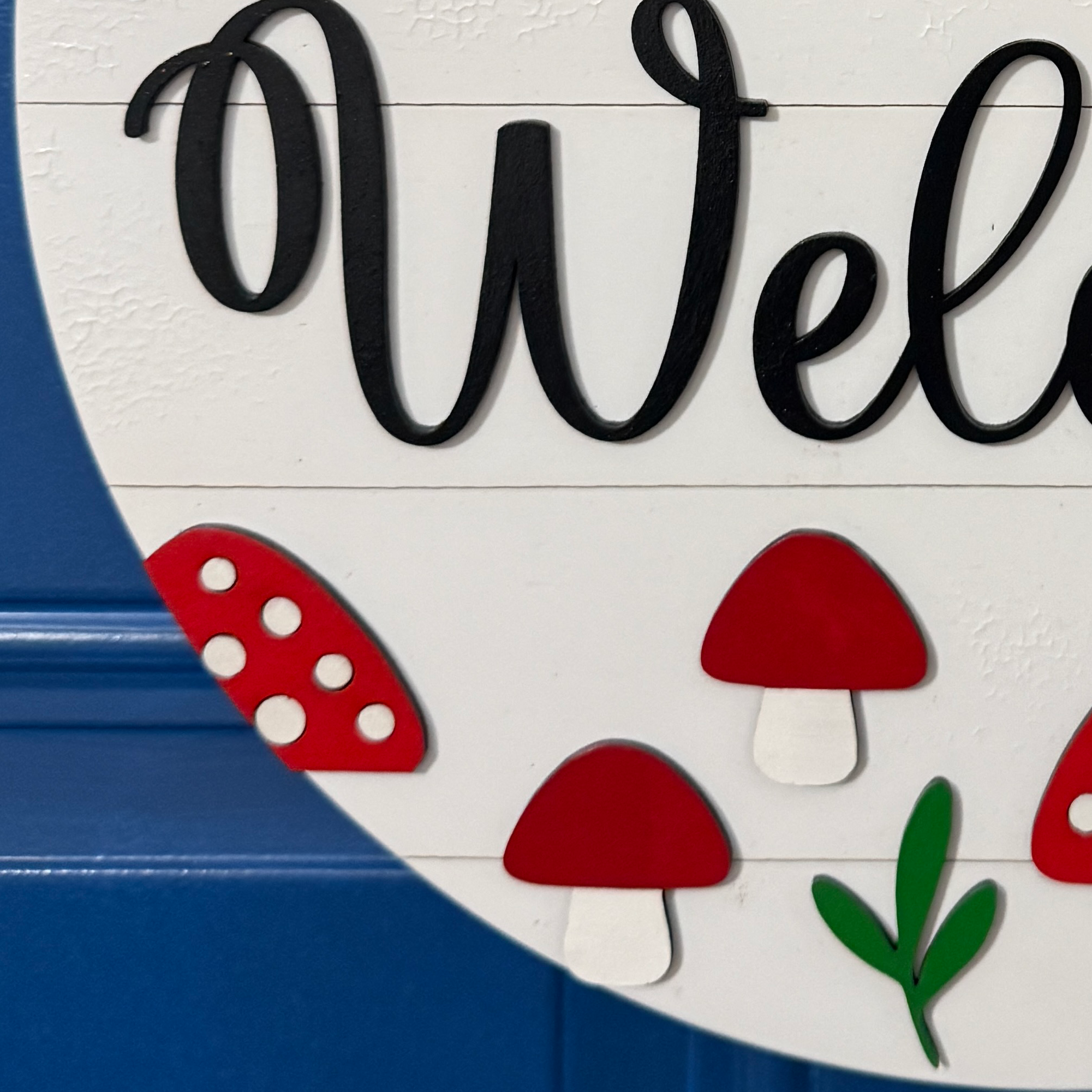 Hand-painted red mushroom accents on round welcome door hanger