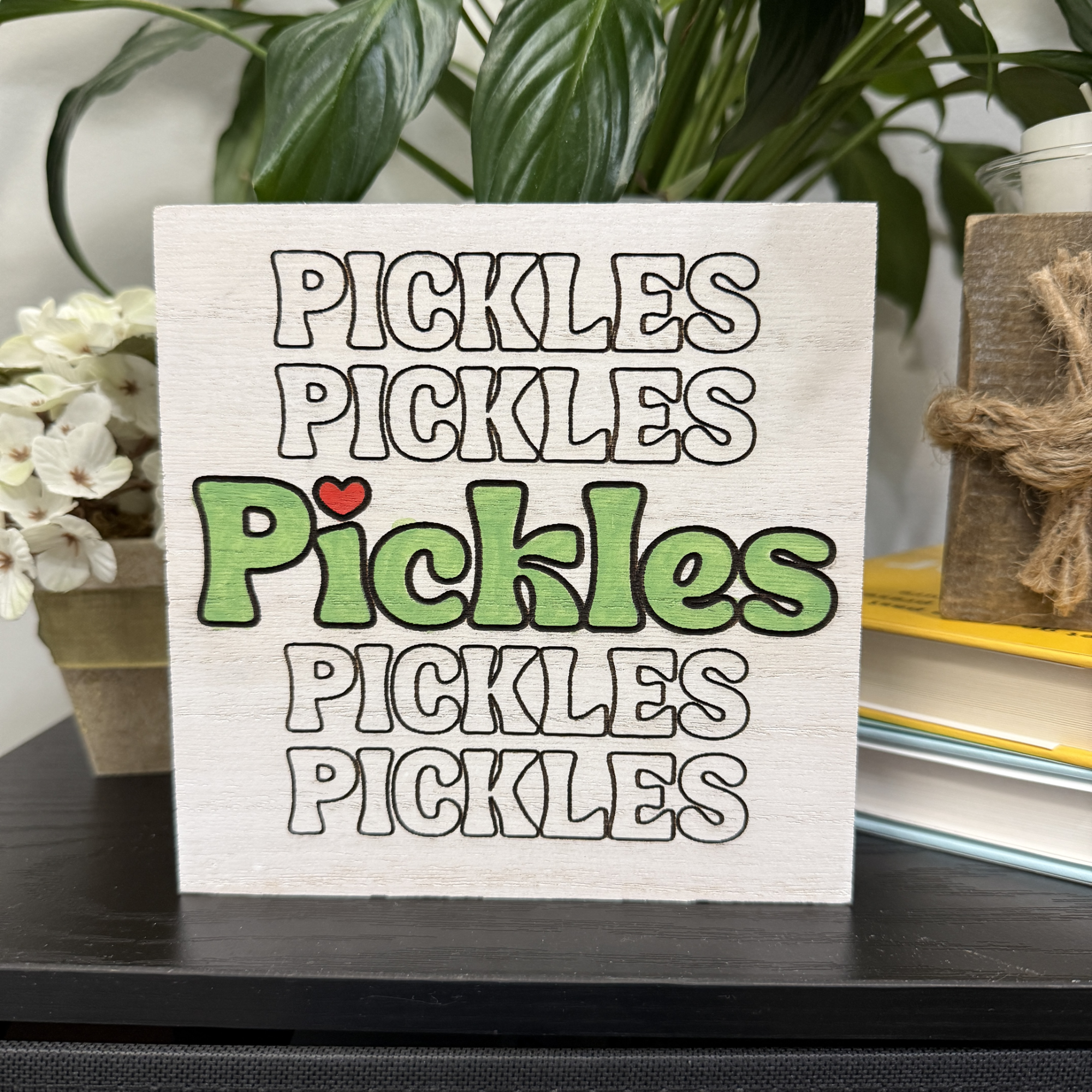 Pickles wood shelf sitter with repeating engraved text and green center lettering on natural wood background