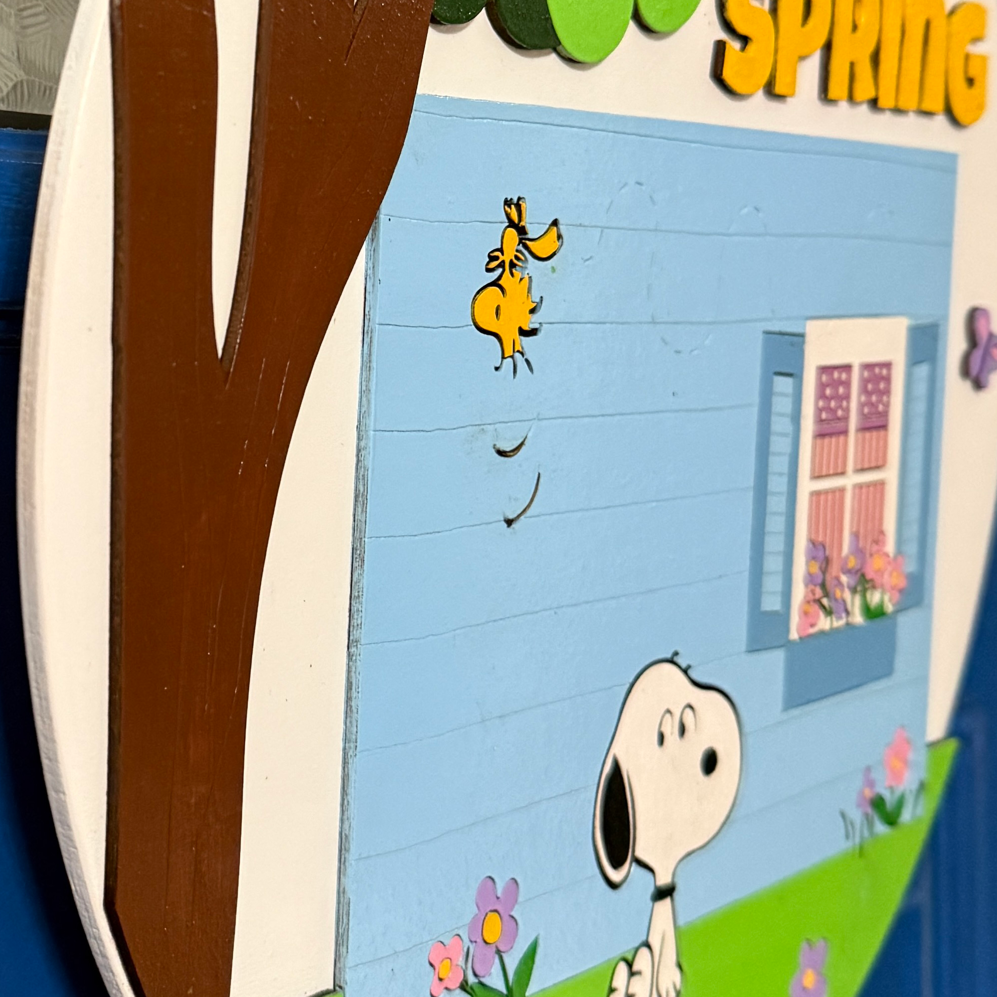 Side angle showing thickness and layered construction of spring-themed door hanger