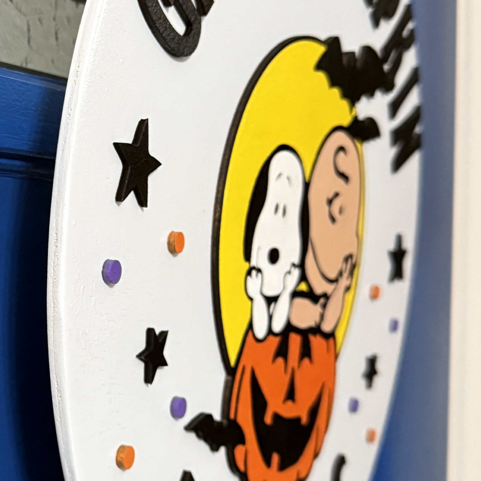 Close-up of Halloween door hanger highlighting hand-painted characters and pumpkin details