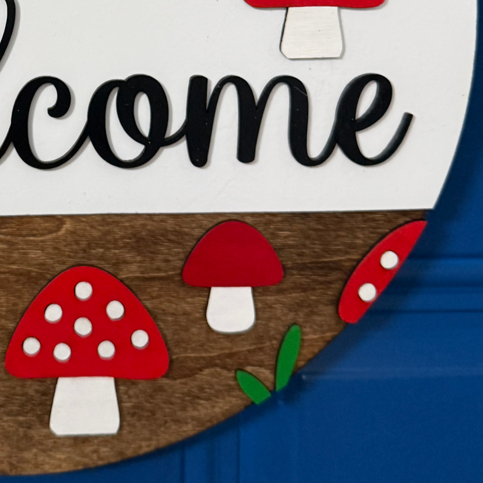 Rustic summer front door décor with mushrooms, greenery, and stained wood base