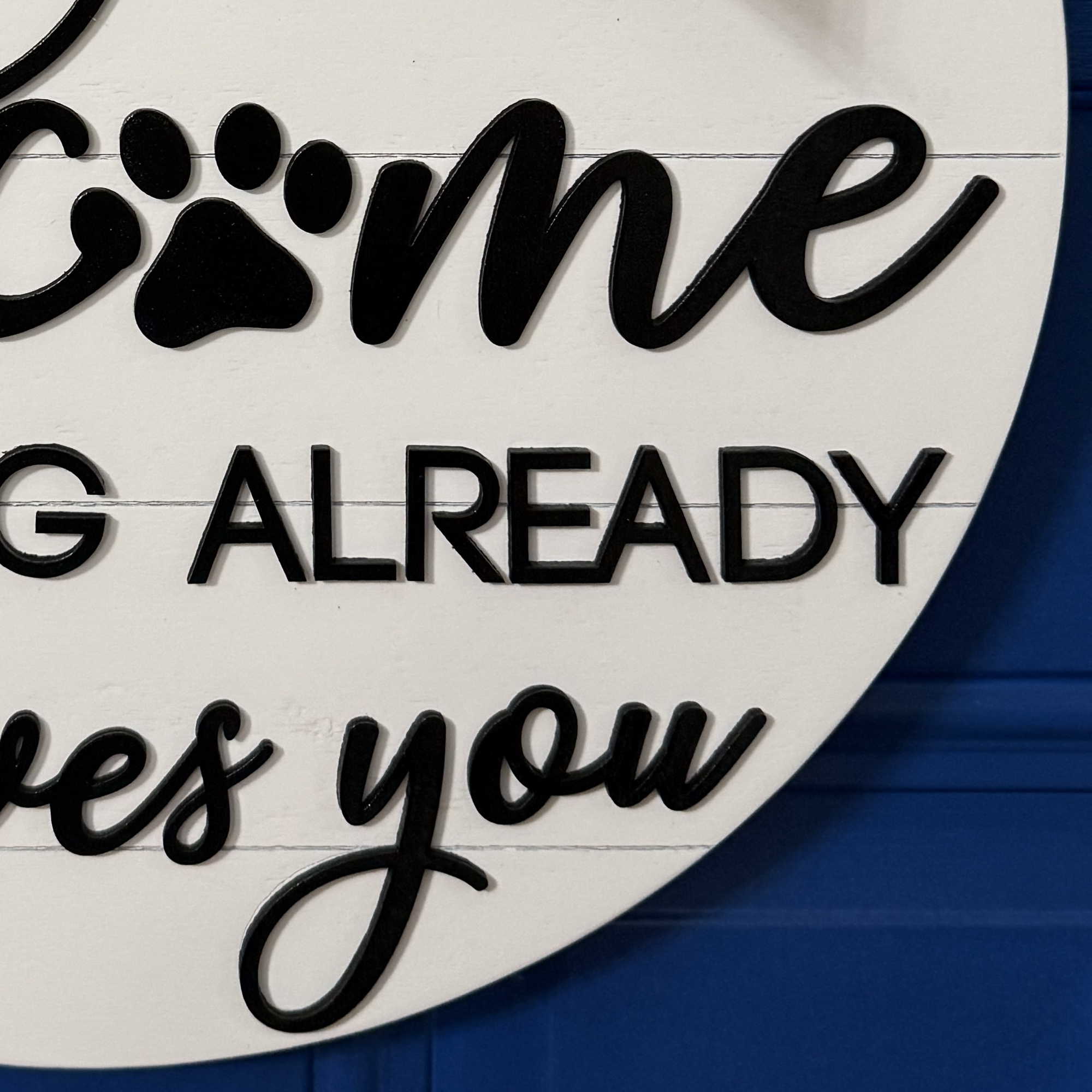 Partial crop of welcome lettering with paw print replacing the letter “o”