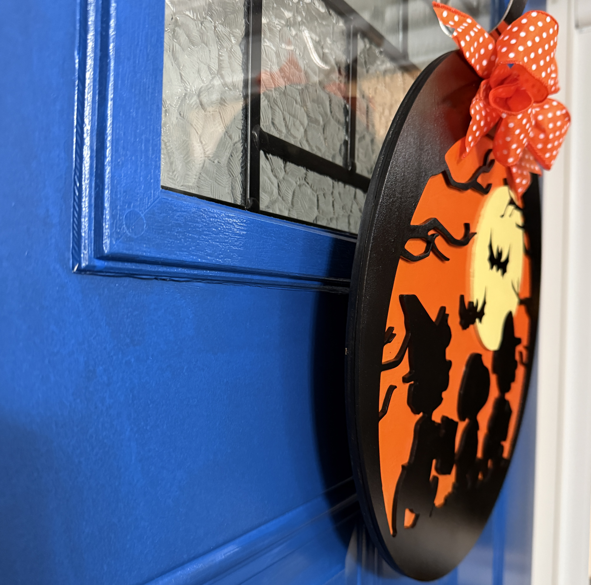 Side view of Halloween Trick-or-Treat door hanger showing layered silhouette details and bow accents