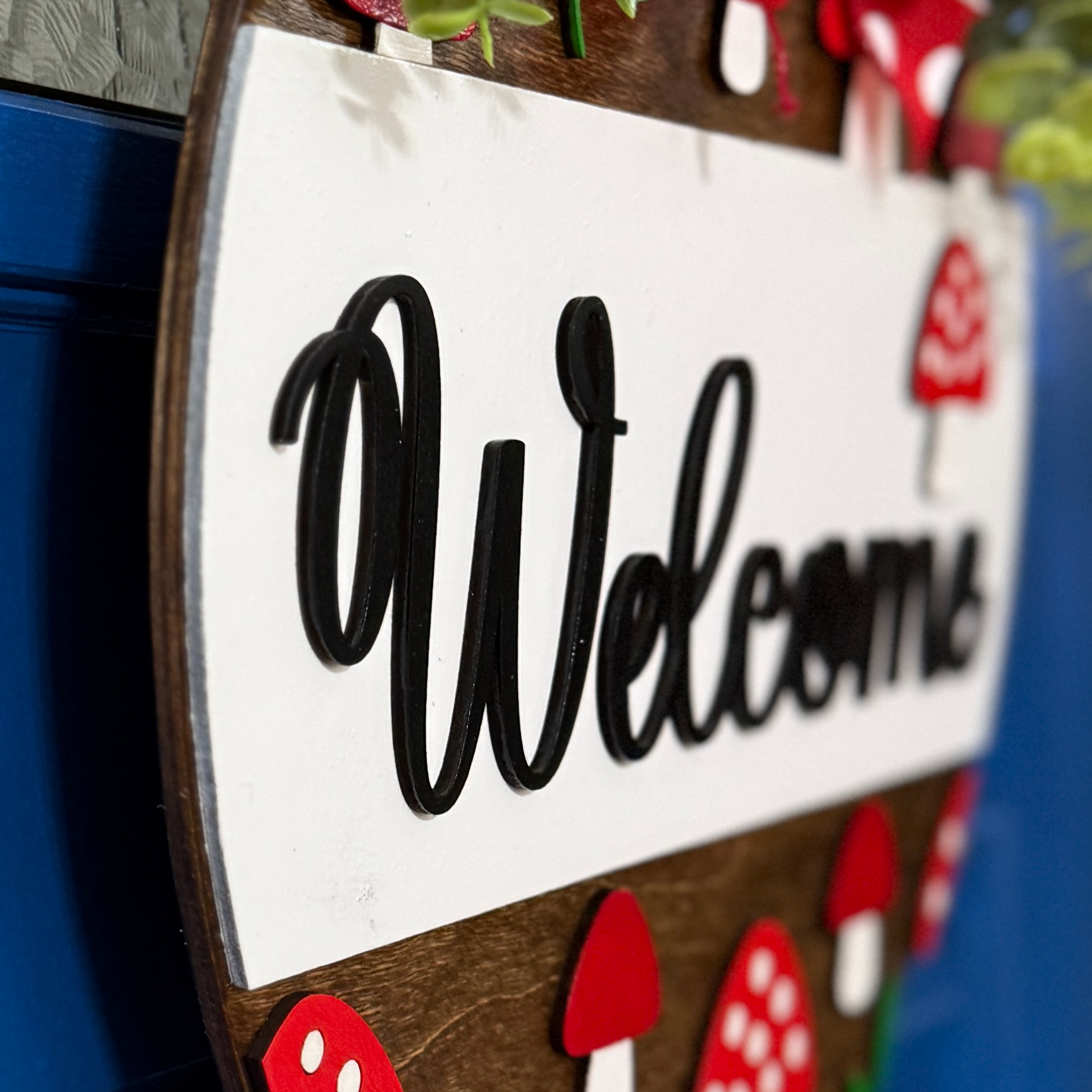 Side view of dimensional mushroom welcome door hanger with woodland-inspired design
