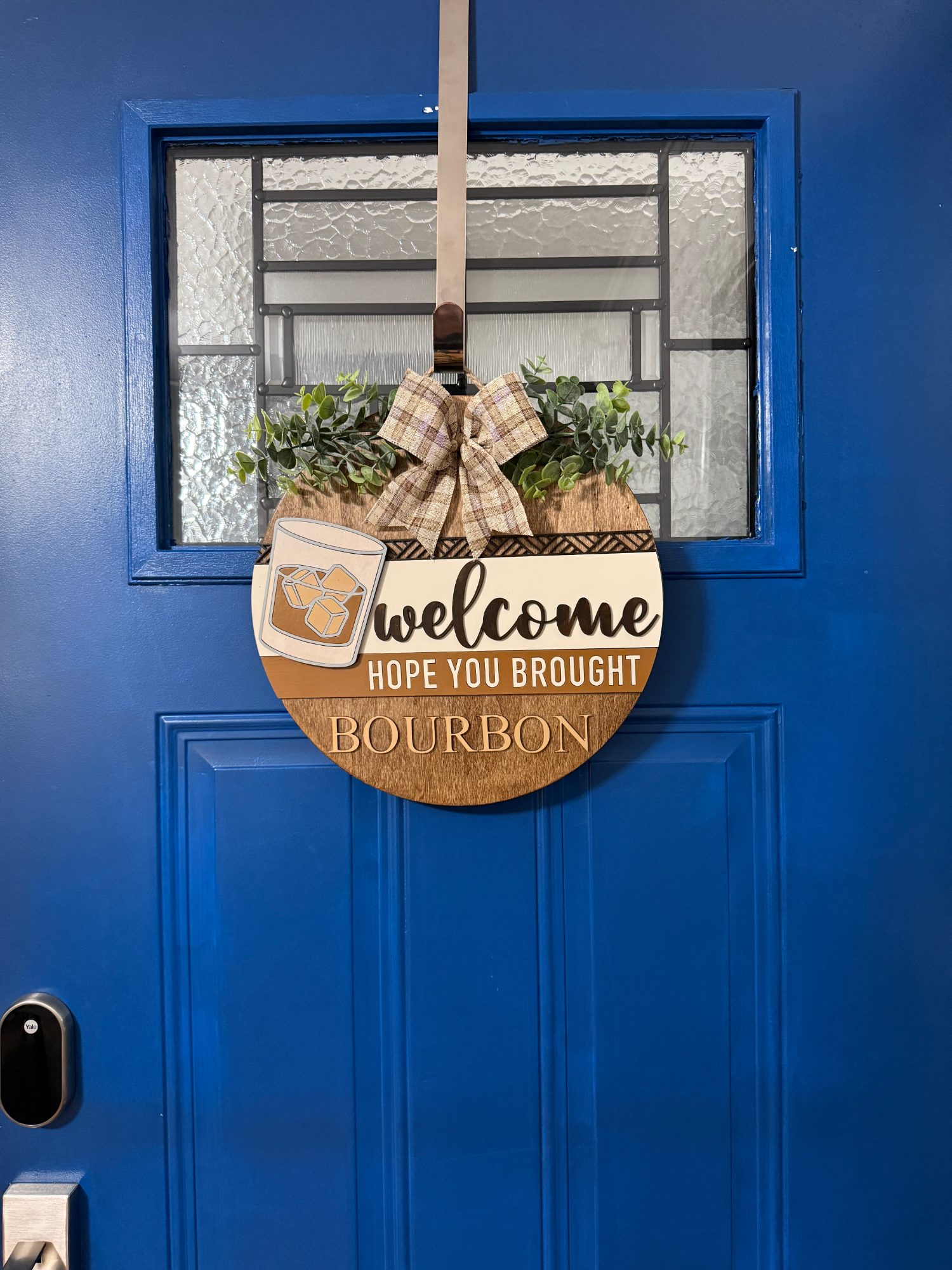 Full view of bourbon door hanger displayed on blue front door