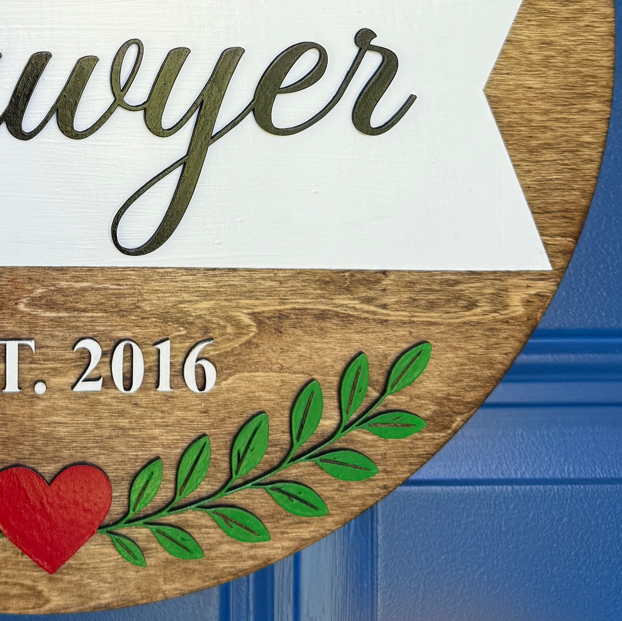 Personalized front door décor featuring custom last name and EST year.