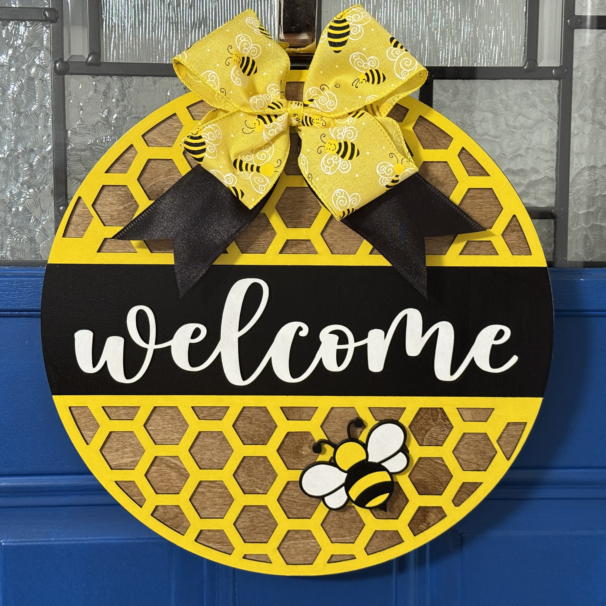 Welcome door hanger on stained base with black background and coordinating bow and bee accent