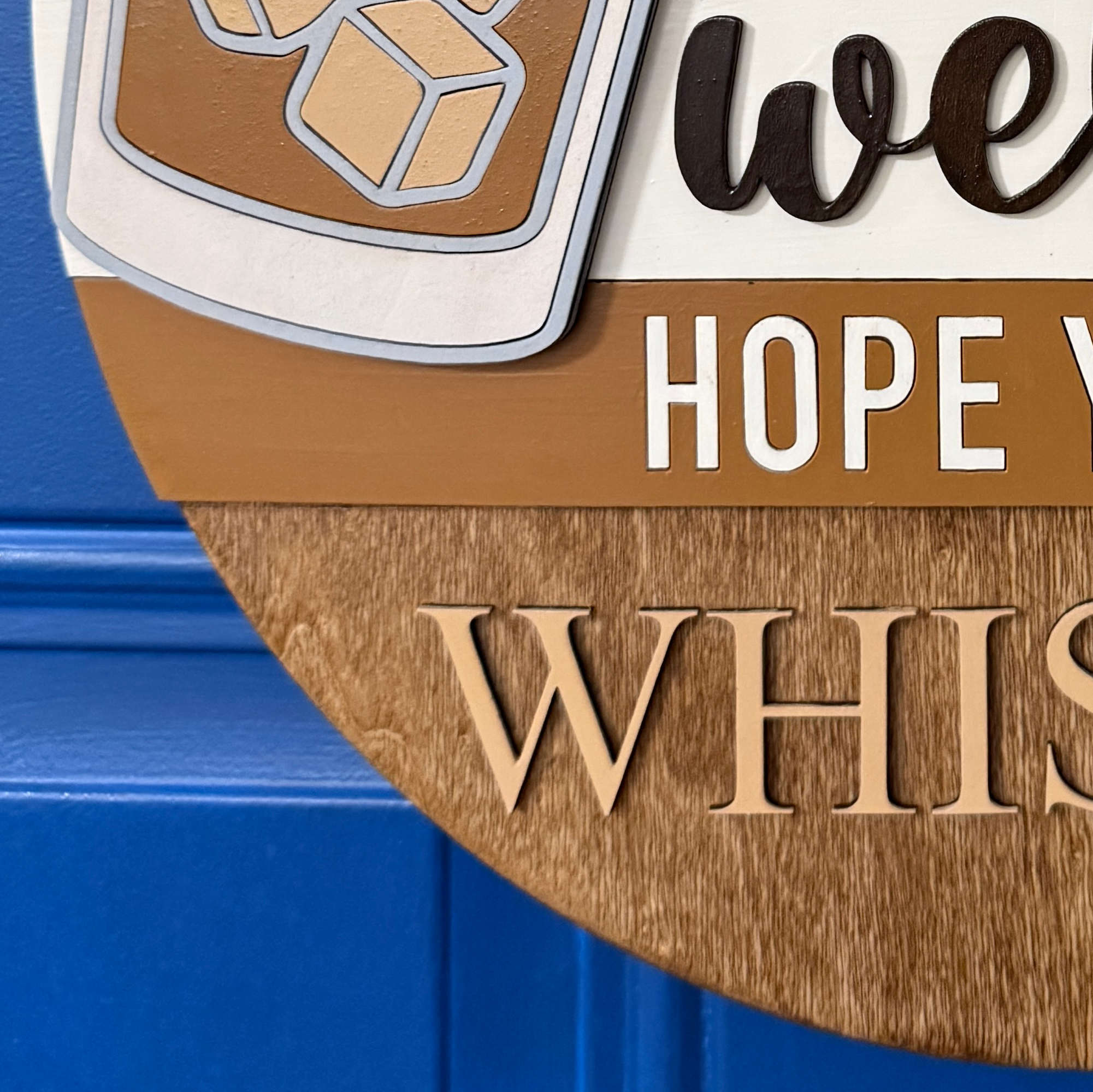 Close-up of “welcome” script lettering in dark brown on cream background