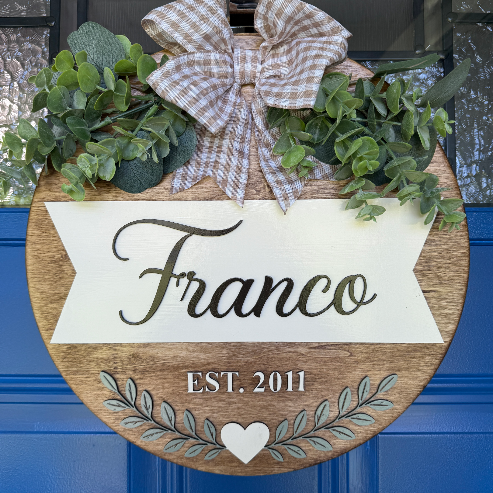 Custom last name front door sign with greenery and established date.