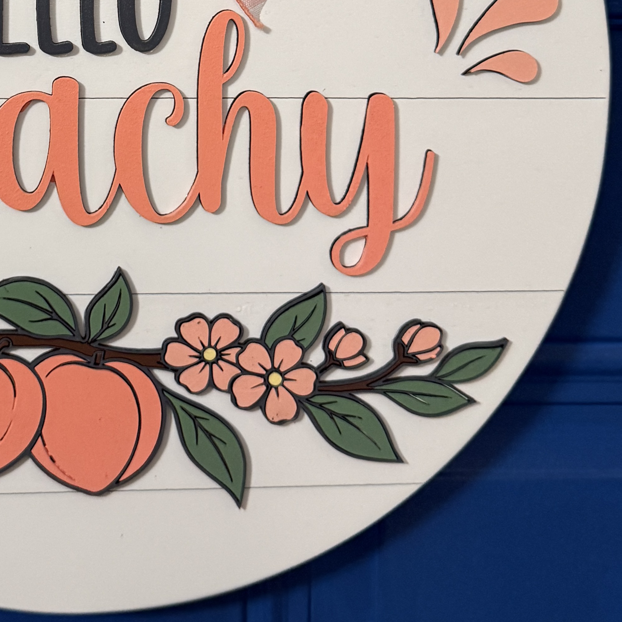 Close-up of coral peaches and floral accents along bottom of Hello Peachy summer decor