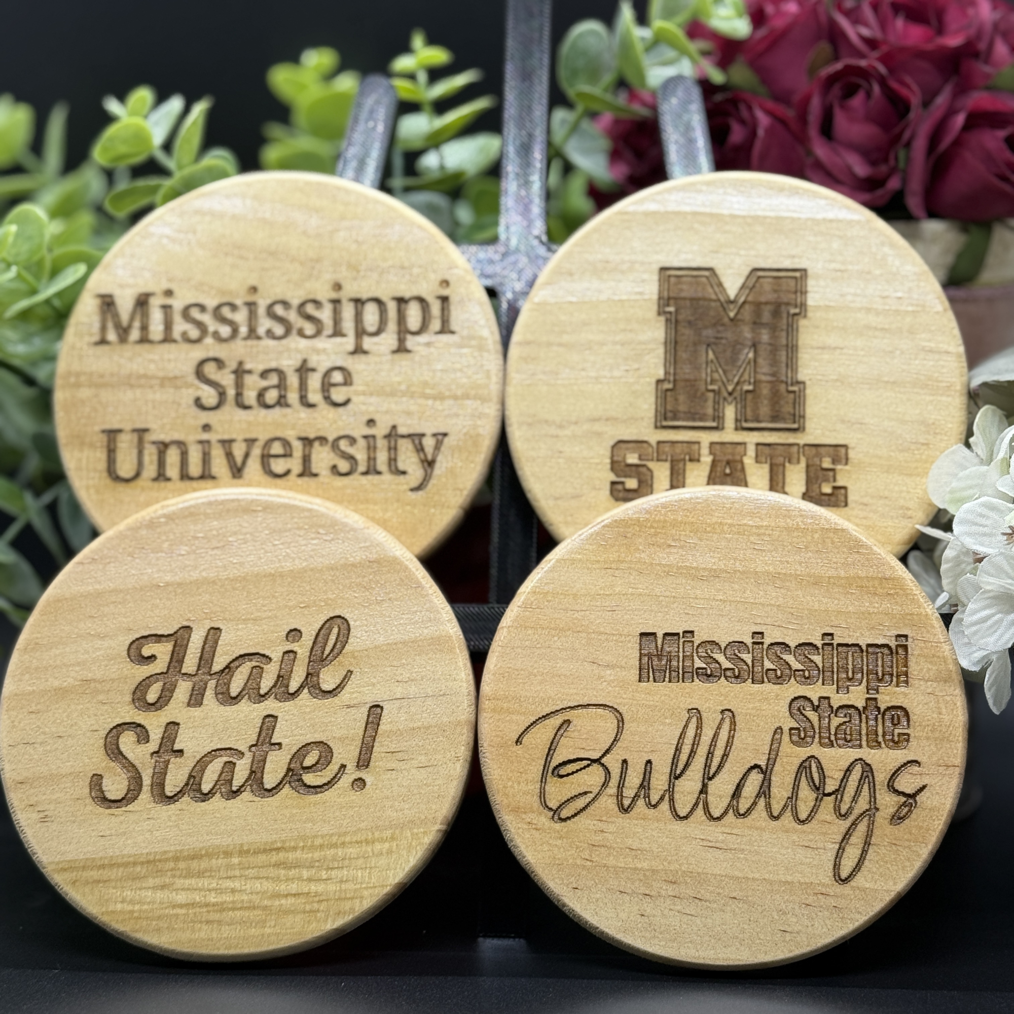 Set of four round Mississippi State Bulldogs engraved wooden coasters with designs including Mississippi State University, M State logo, Hail State, and Bulldogs script