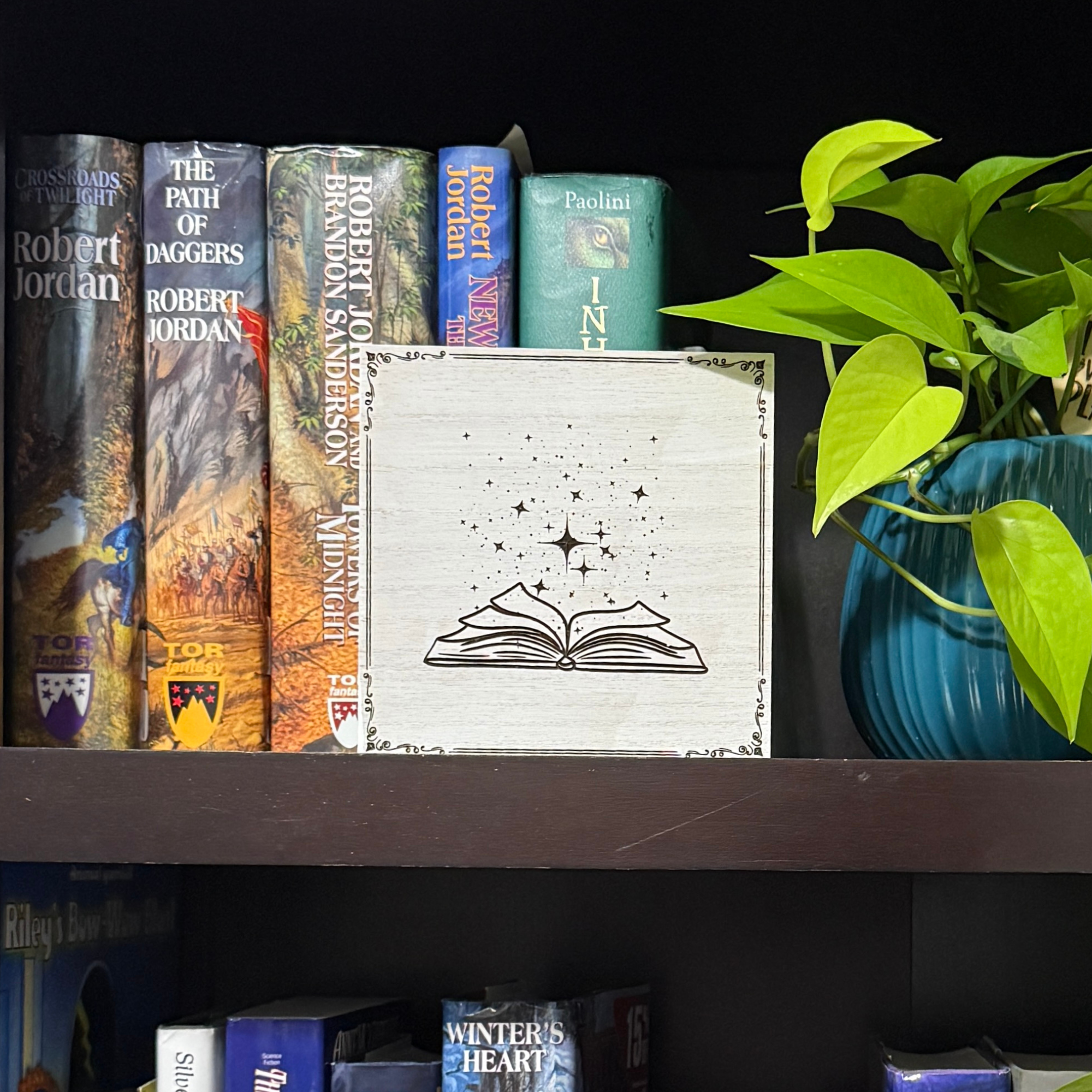 Arcane book shelf sitter displayed on a bookshelf with fantasy novels and dragon decor, highlighting engraved celestial star details