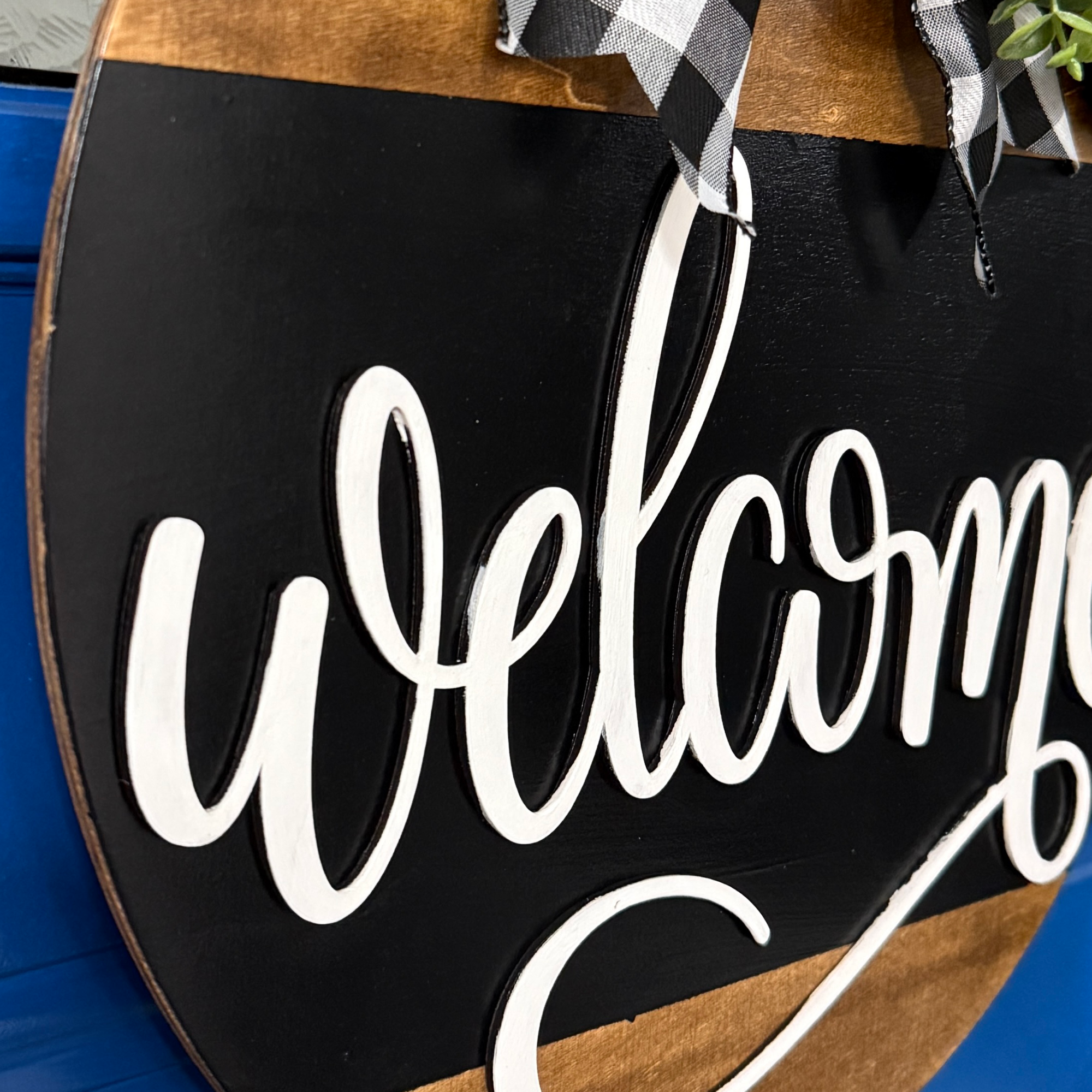 Welcome door hanger, side view, showing base thickness and layered wood details