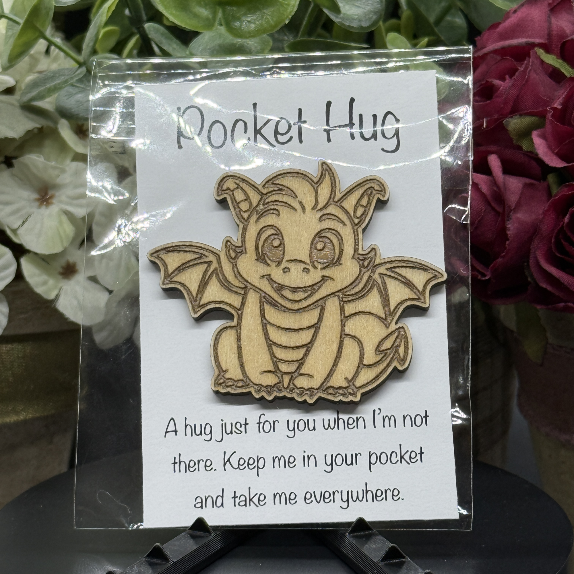 Spunky Dragon Pocket Hug token on printed card – wide-eyed dragon with raised wings and floral backdrop
