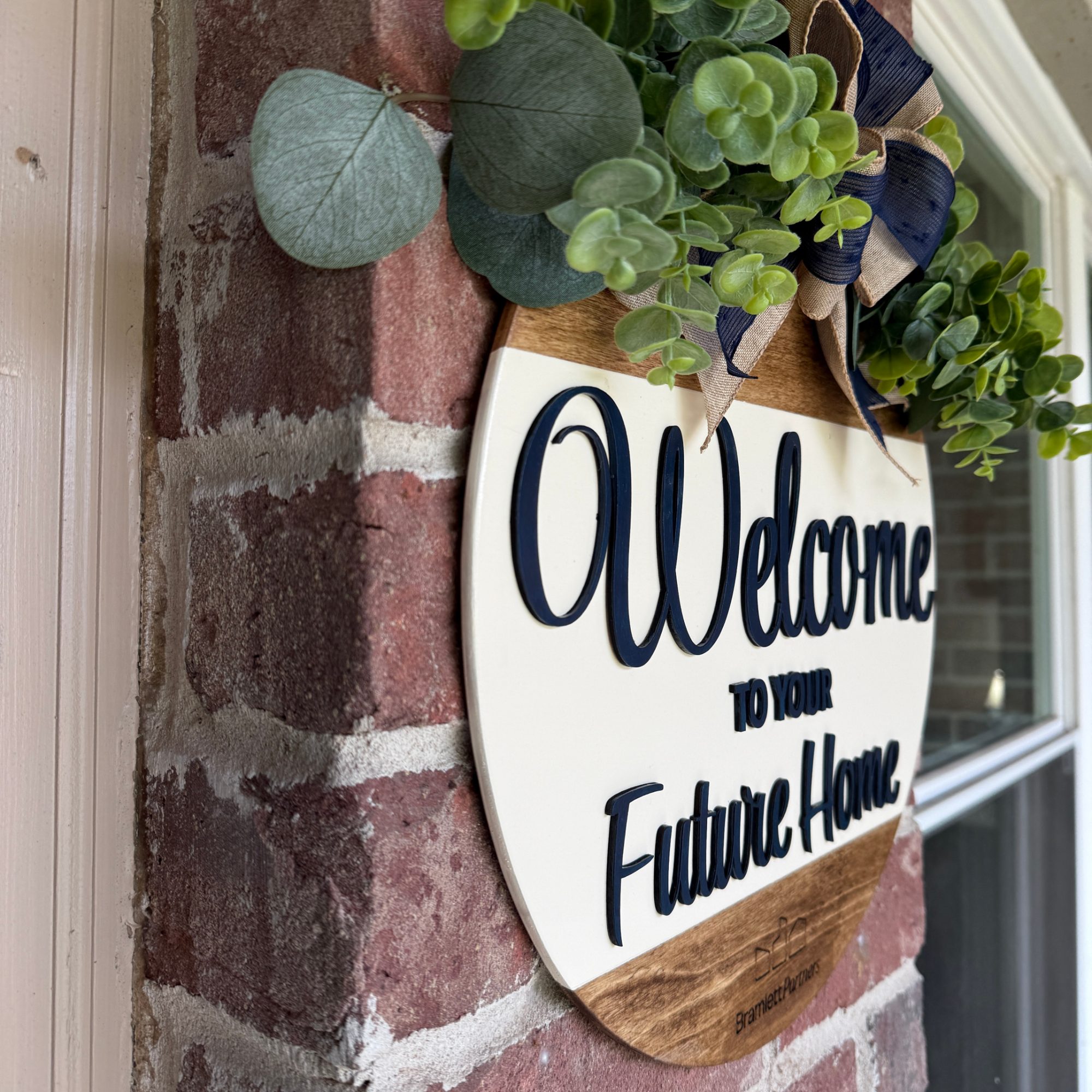 Close-up of custom realtor door hanger with layered lettering and engraved logo.
