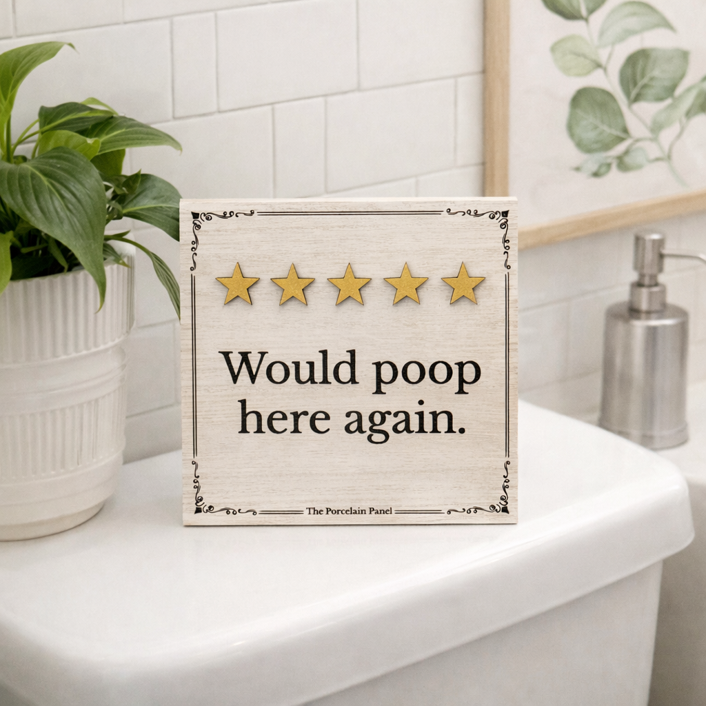 Wooden bathroom sign reading would poop here again with five gold stars displayed on a toilet tank in a clean modern bathroom