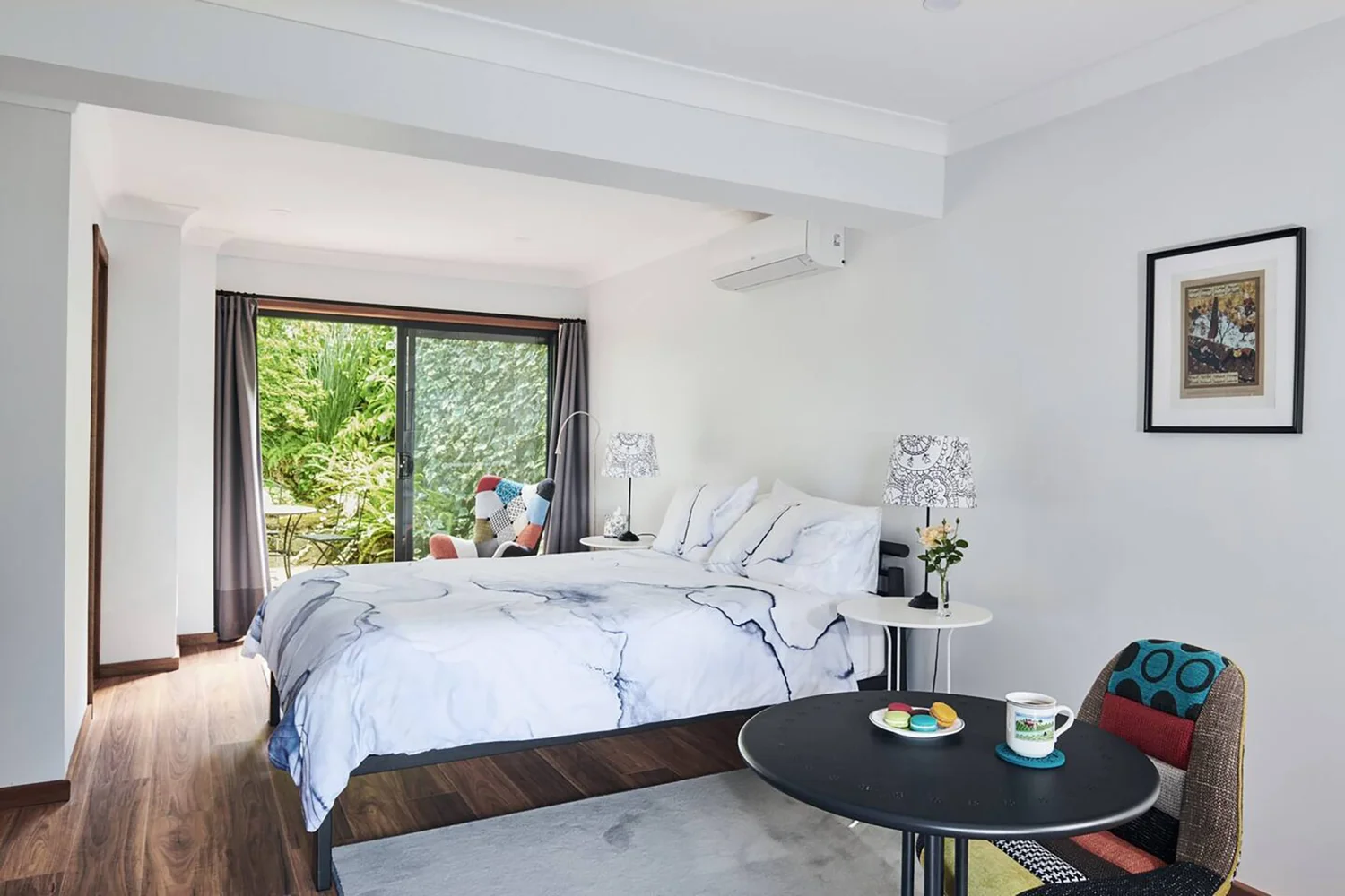 Bright, modern bedroom with garden views at Mountain Sojourn, a sustainable renovation by Dadirri Architects