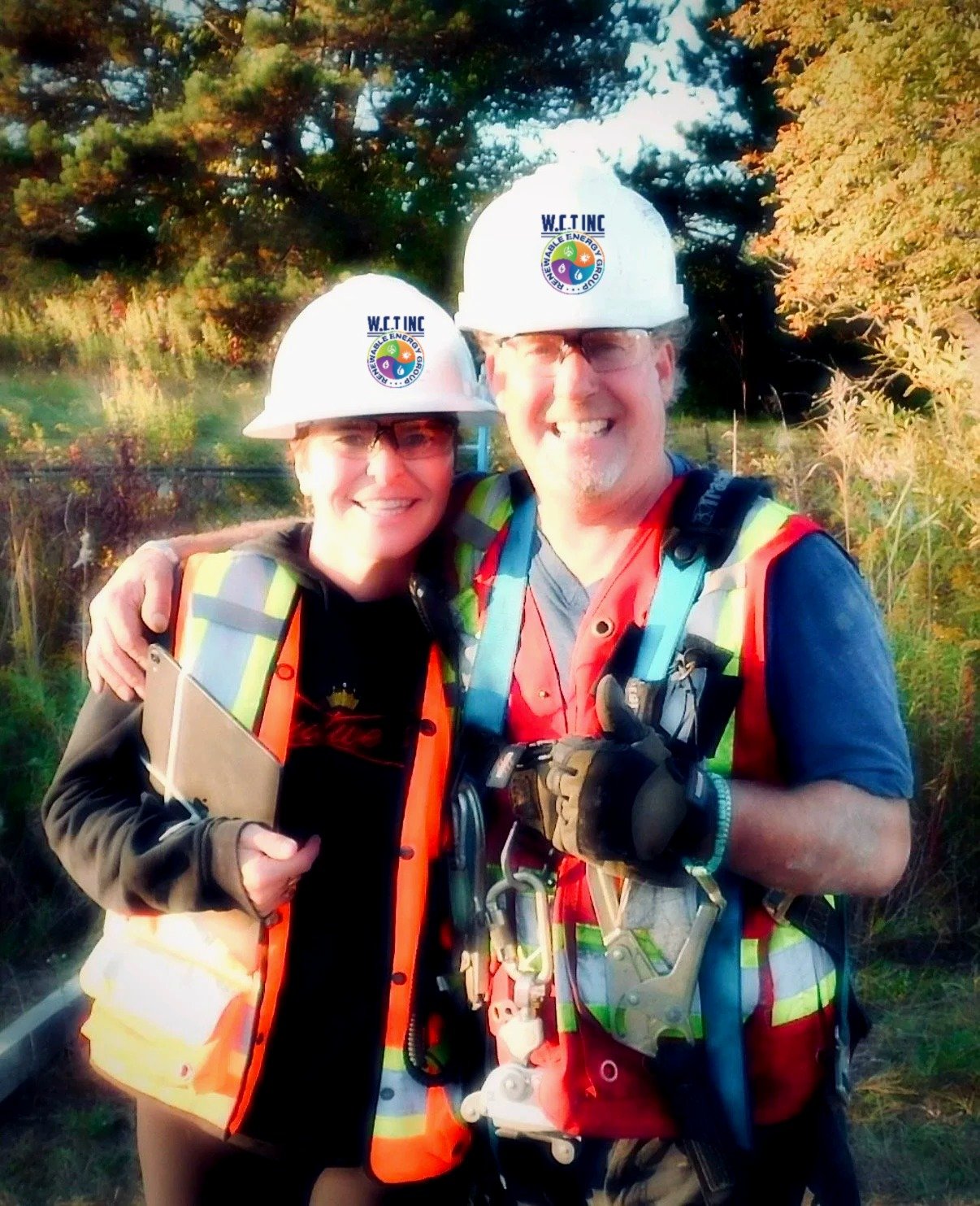 Rob and Kim of Wind Turbine Construction Team Inc. in hard hats and hi-vis on a wind project site