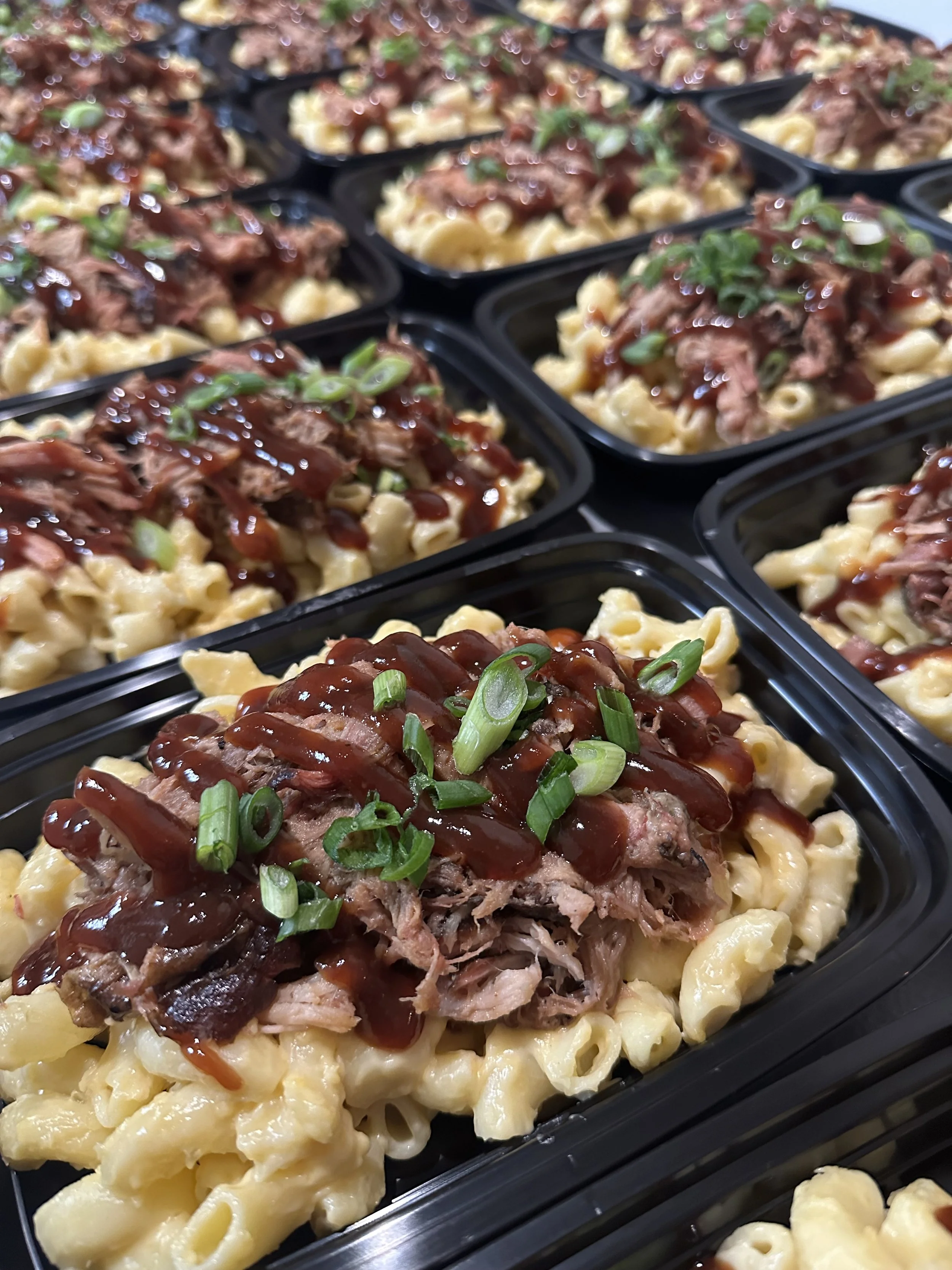 Row of meal prep containers filled with chicken fried rice topped with green onions.