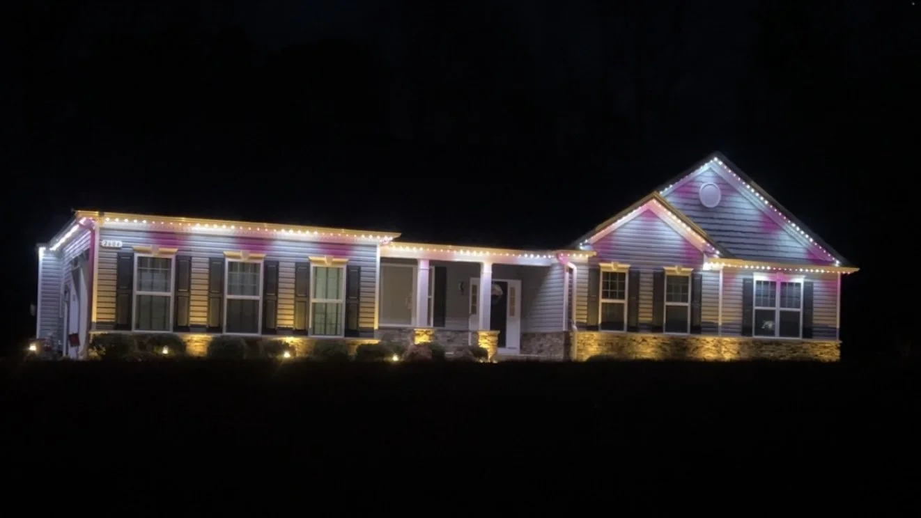 A house decorated with colorful holiday lights at night.