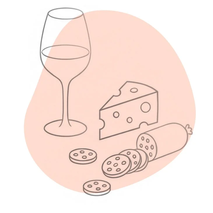 Un verre de vin, un morceau de fromage avec des trous, et plusieurs rondelles de saucisson ou de biscuit sur un fond rose clair.