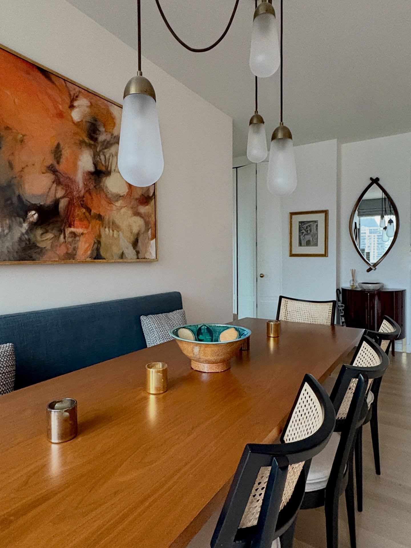 A recent project where midcentury warmth, texture, and clean lines do the heavy lifting. Cane, walnut, and soft lighting, paired with a stunning @apparatusstudio Lariat pendant, come together to create a dining area that feels intimate yet effortless