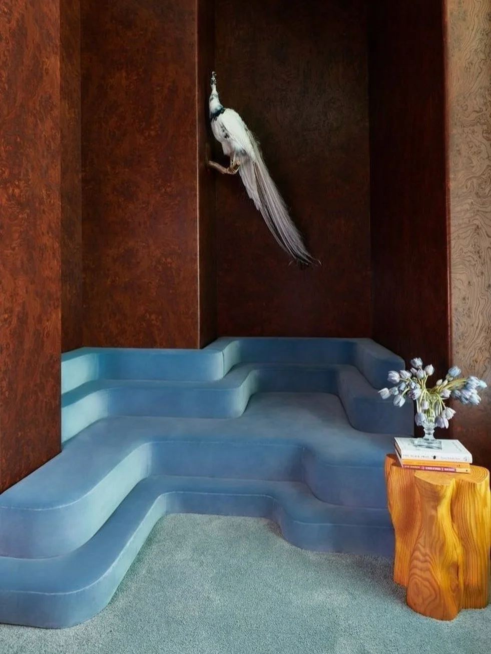 A room that behaves more like a landscape than a seating area. Soft steps, rich materiality, and a moment of surrealism suspended above it all.