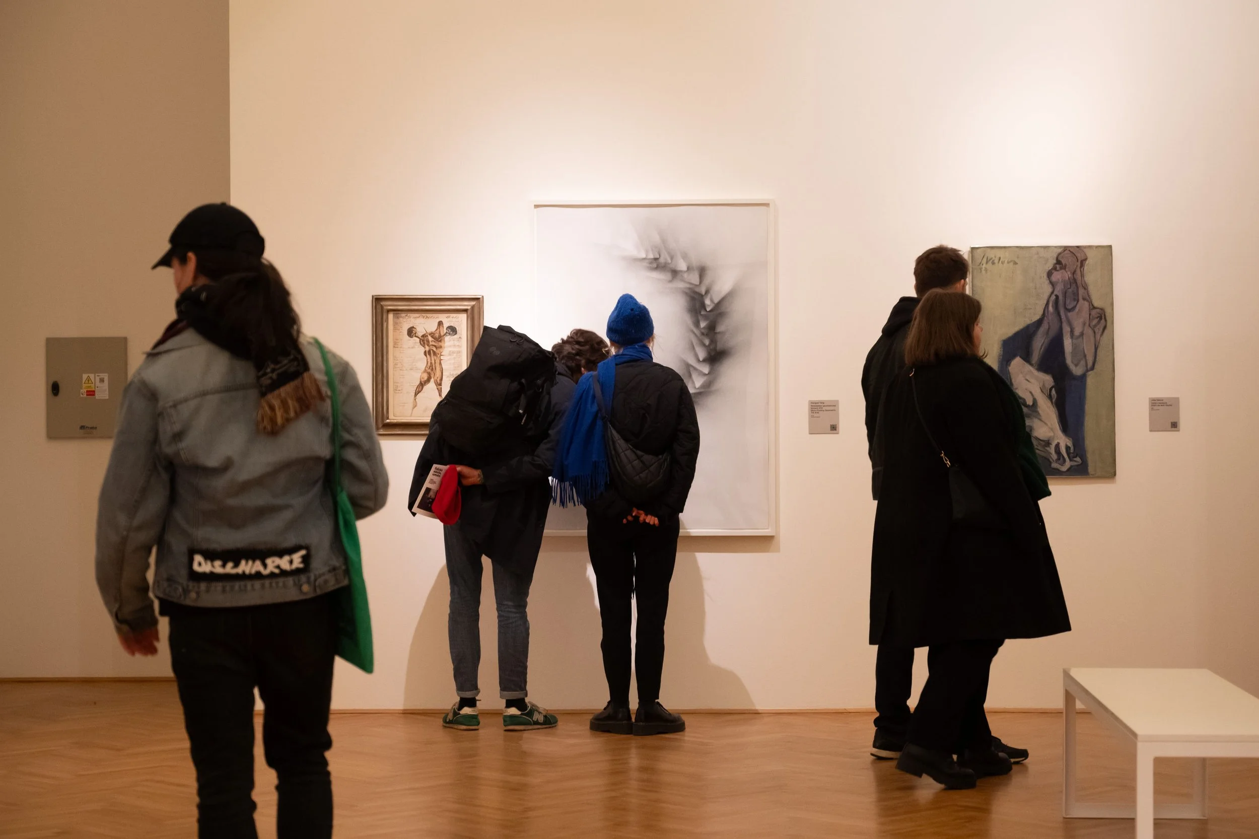 Inside Lidice Gallery visitors observe works by Aleš Veselý and Haegue Yang on white gallery wall.