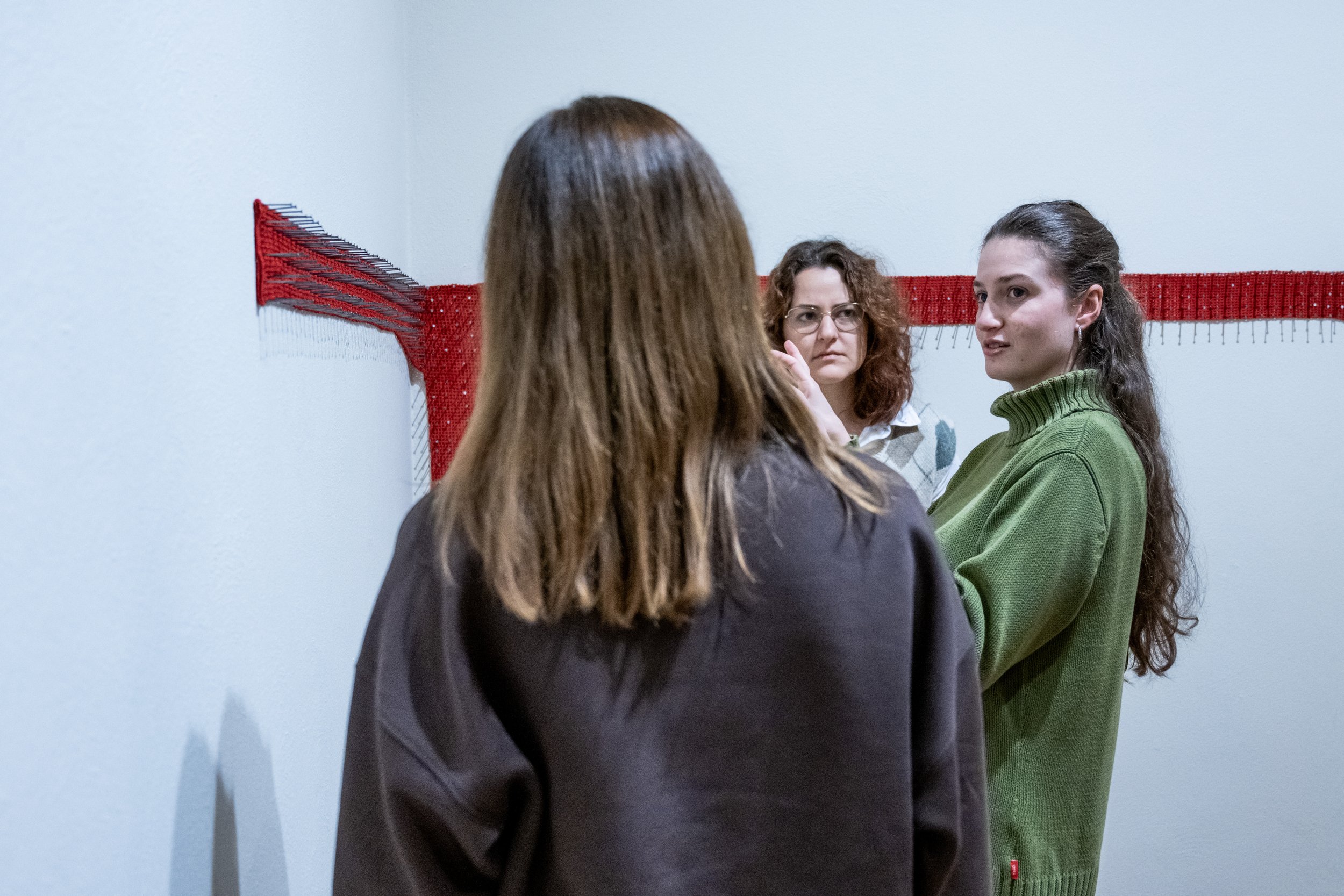 Three European Solidarity Residency 2025 participants in conversation at the Lidice Gallery in front of their exhibited works.